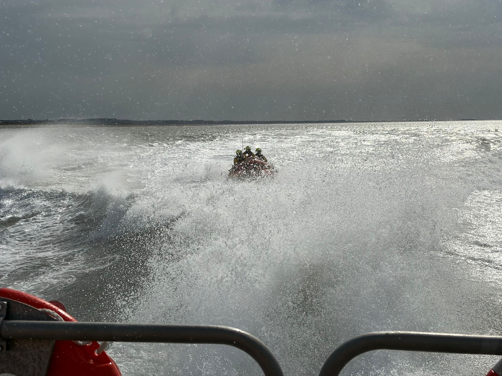 Wells RNLI inshore lifeboat behind Shannon class lifeboat in spray 