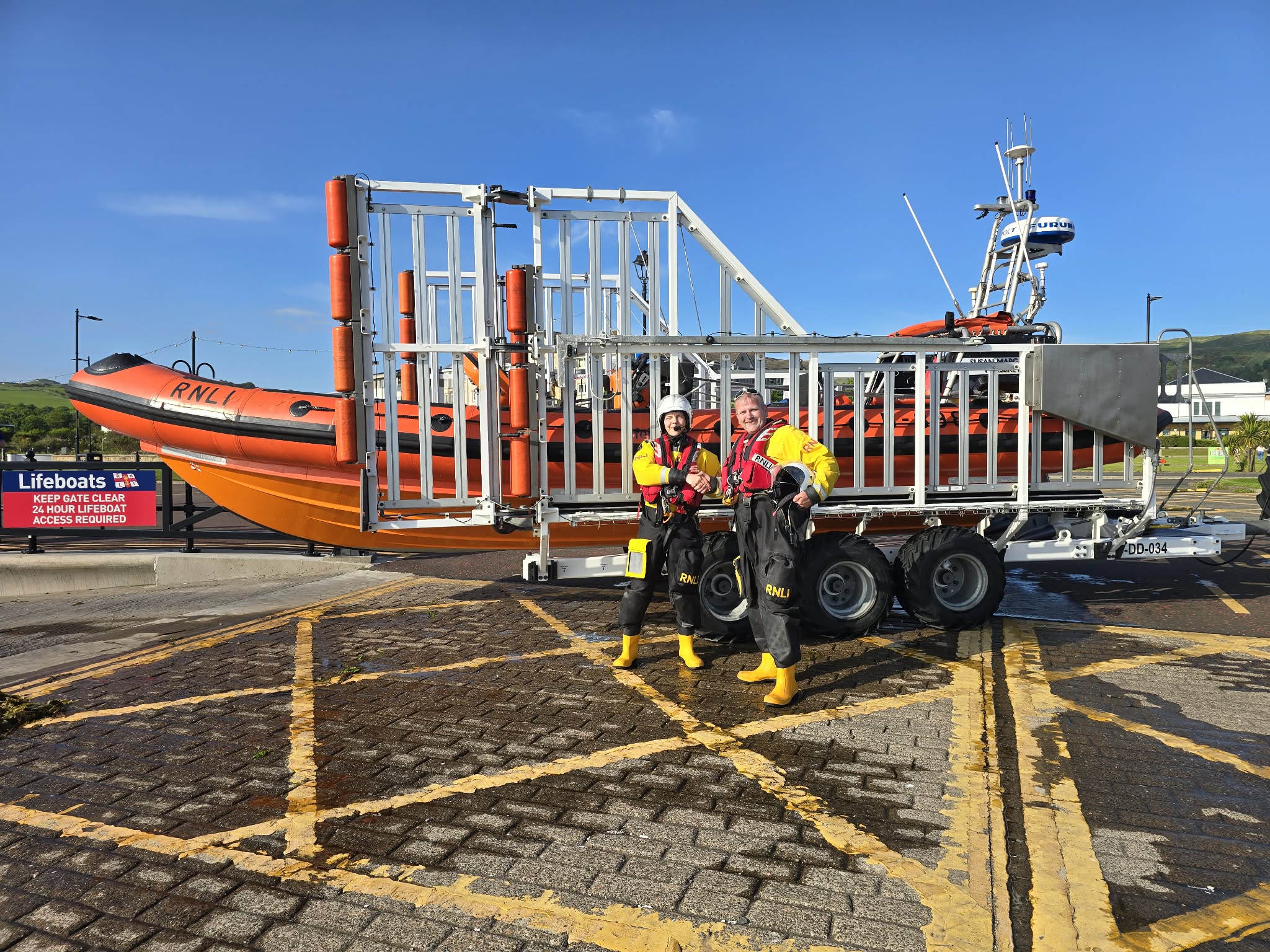 The pair standing in front of the lifeboat 