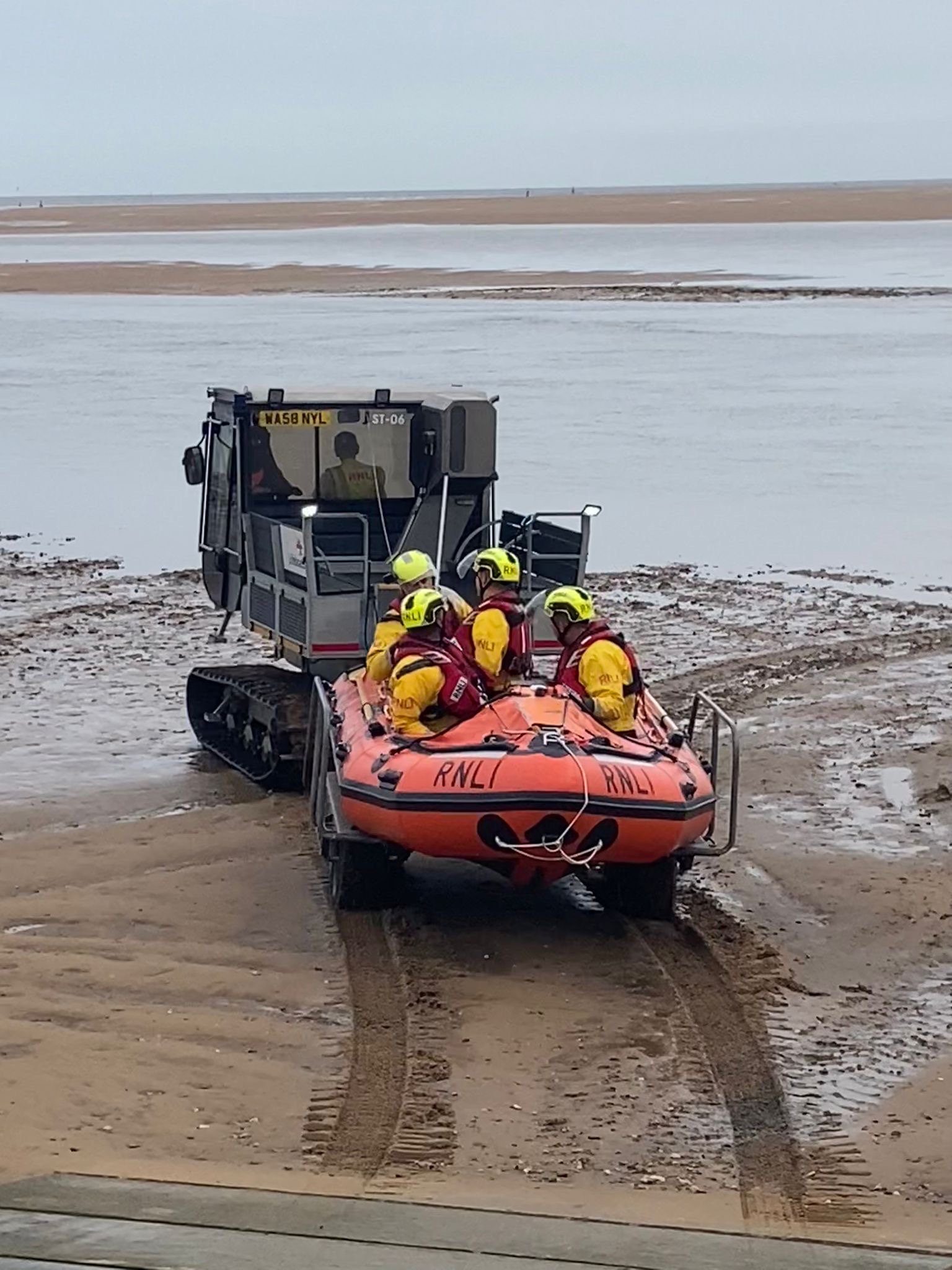 Wells RNLI Inshore lifeboat being towed by Softrak with a volunteer crew of four.
