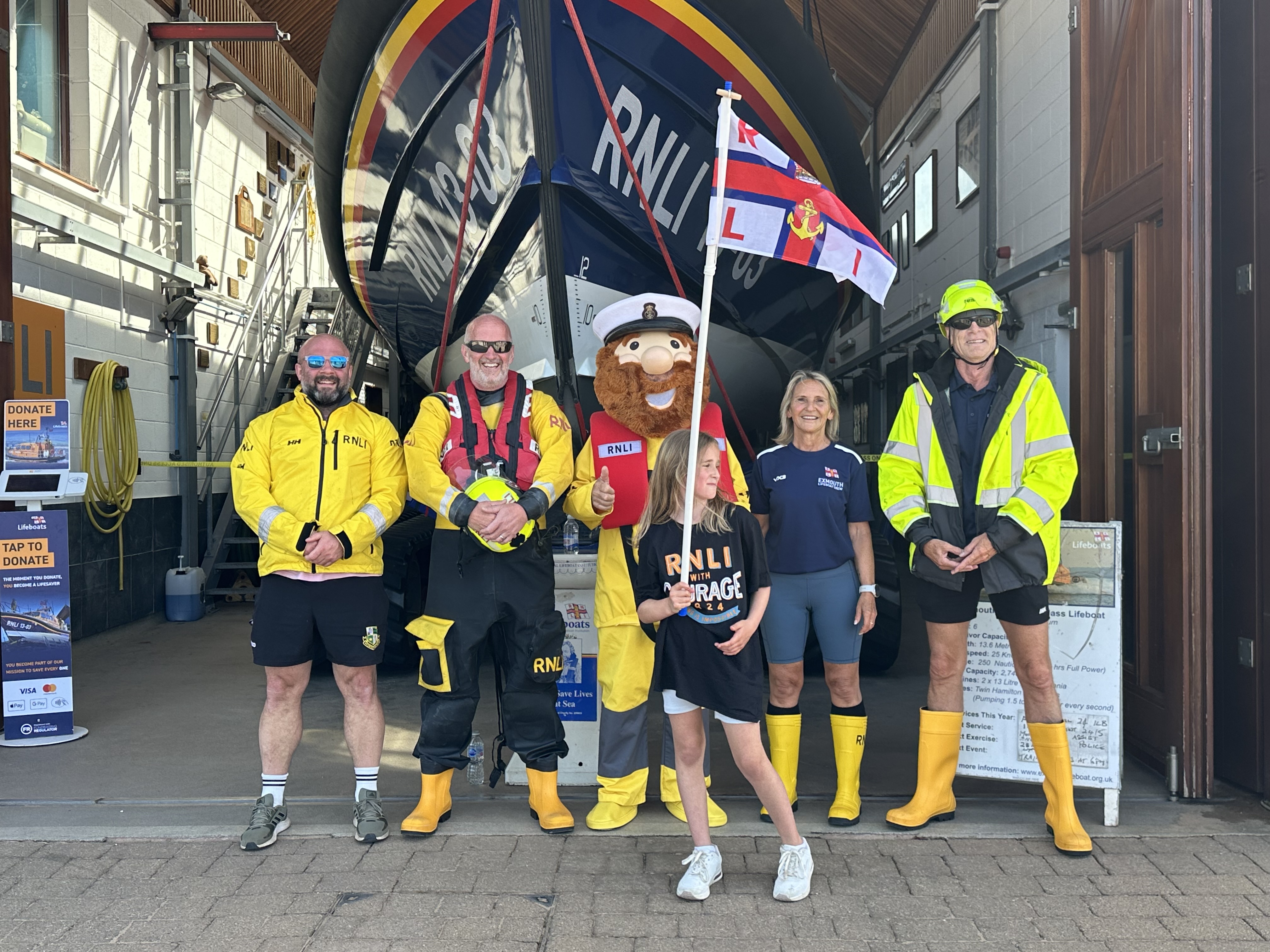 Ivie and Exmouth RNLI volunteers in front of all-weather lifeboat, 13-03 R and J Welburn at the end of their Mayday mile