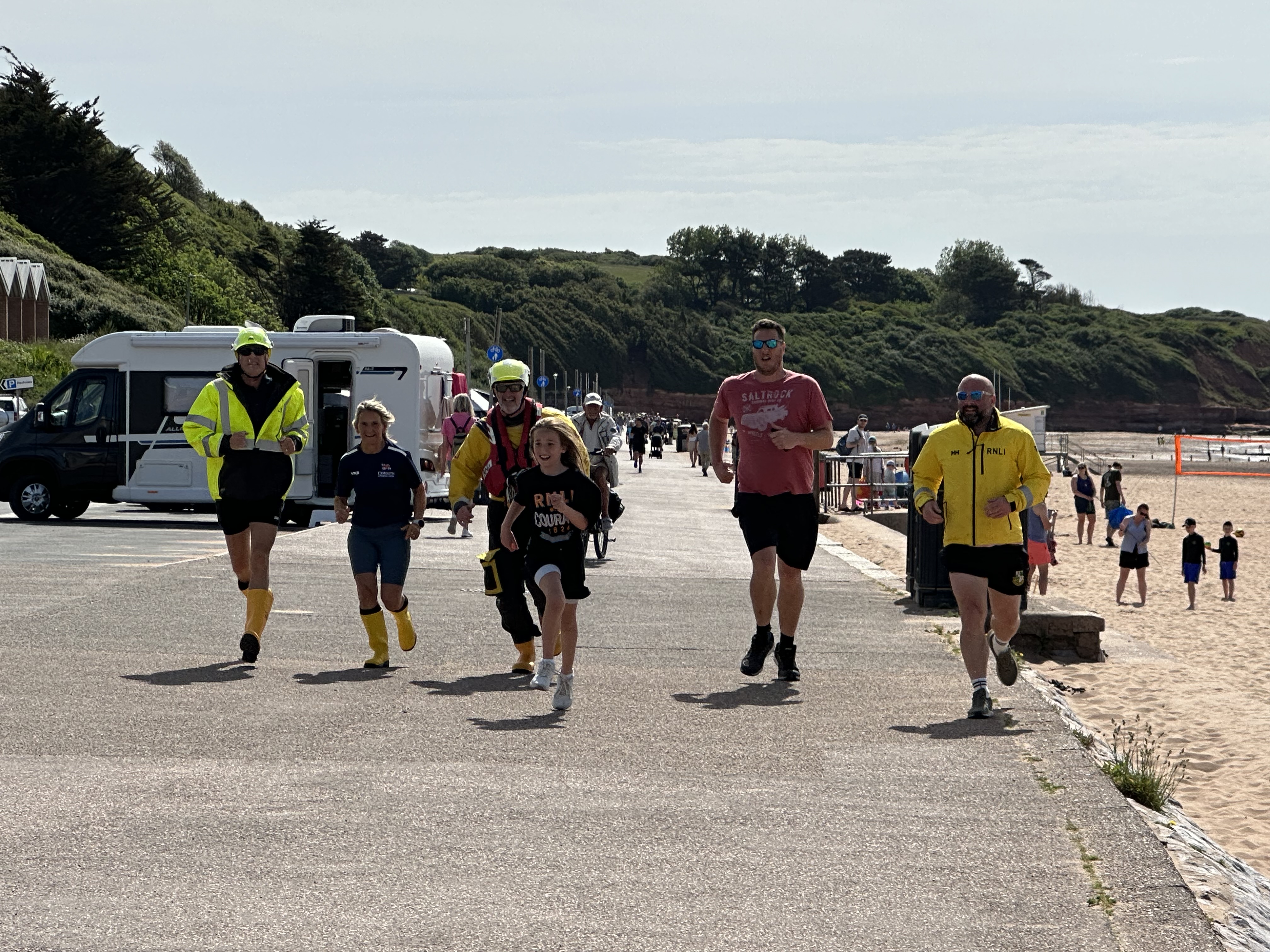 Ivie finishing her Mayday Mile alongside her Dad and volunteers from Exmouth RNLI