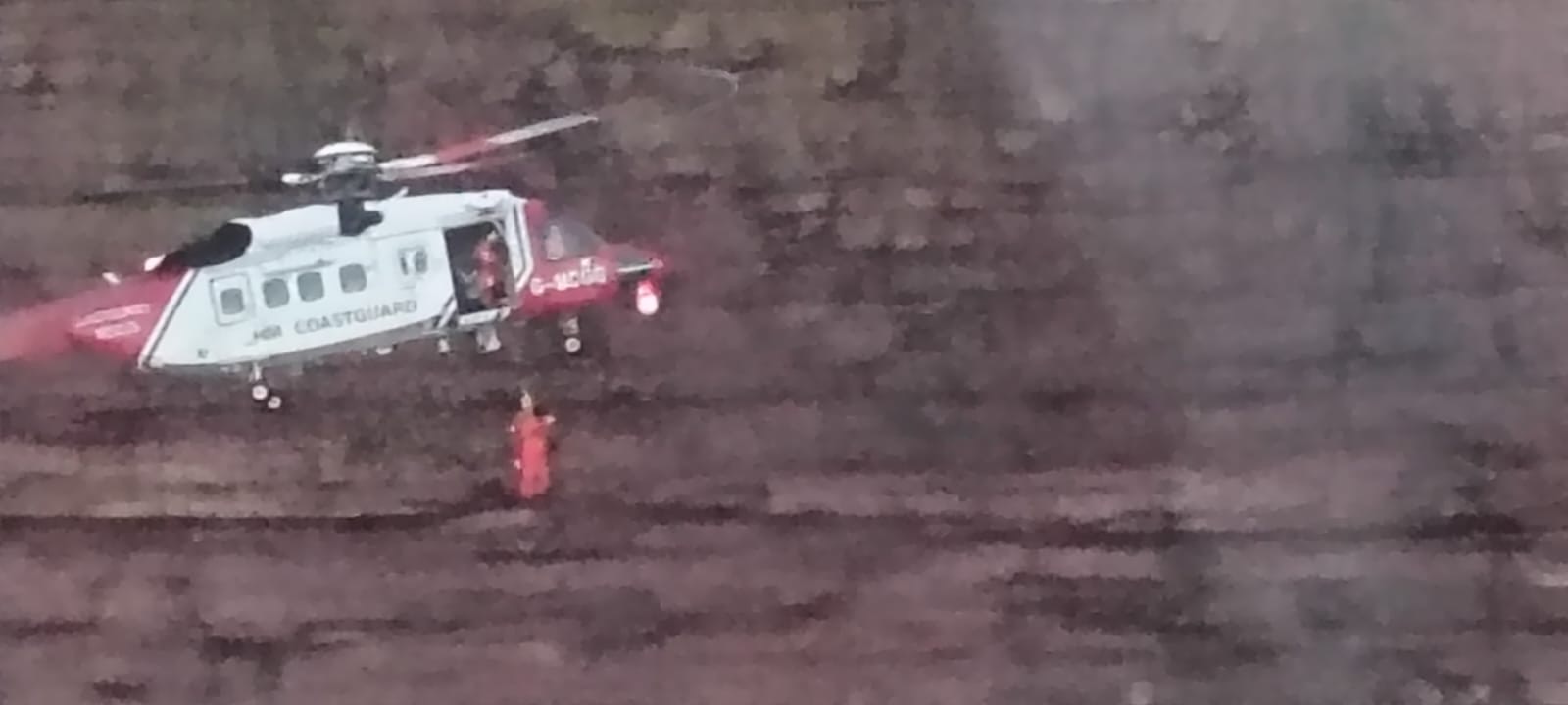 A helicopter is winching a crew man down to the casualty vessel