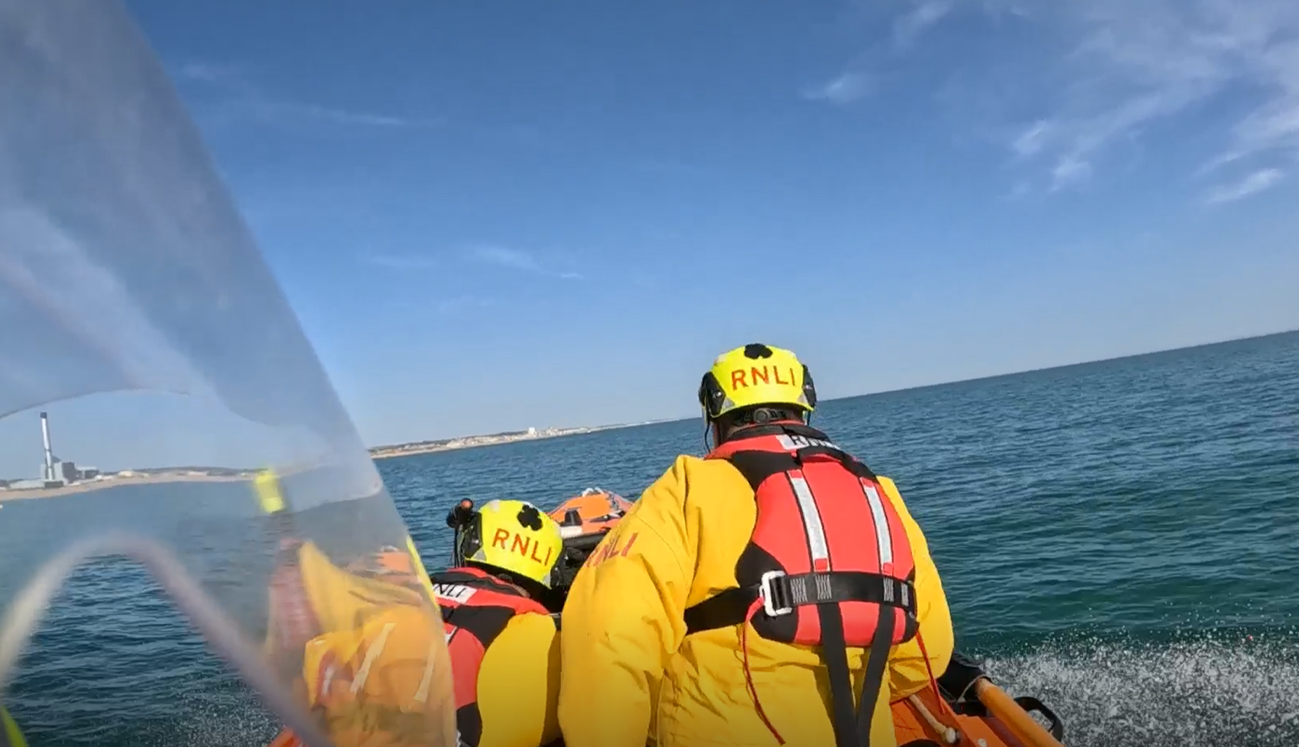 Image of back of two crew members onboard the inshore lifeboat