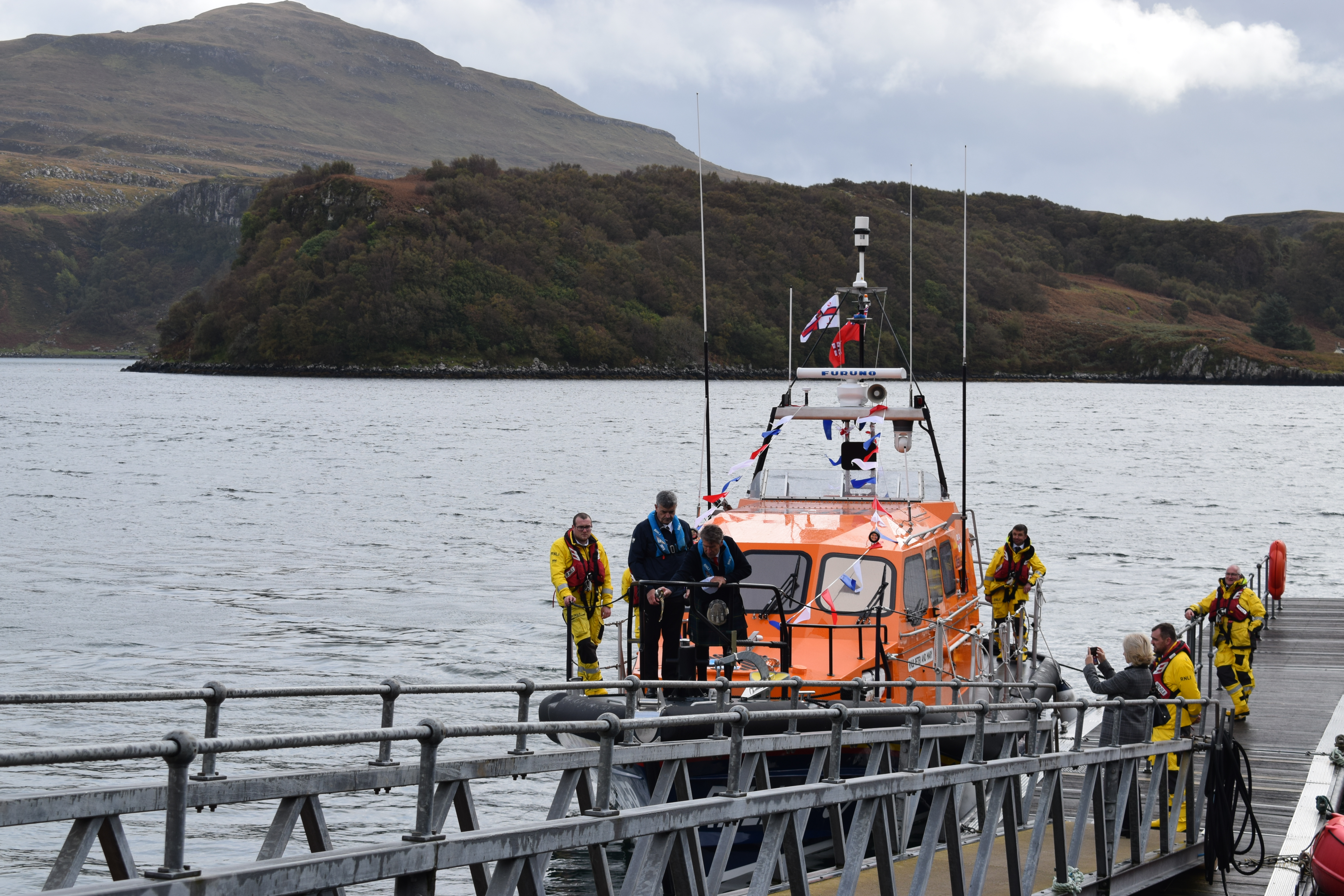 Isle of Raasay Distillery malt whisky being poured over the bow of RNLB Peter and Mary