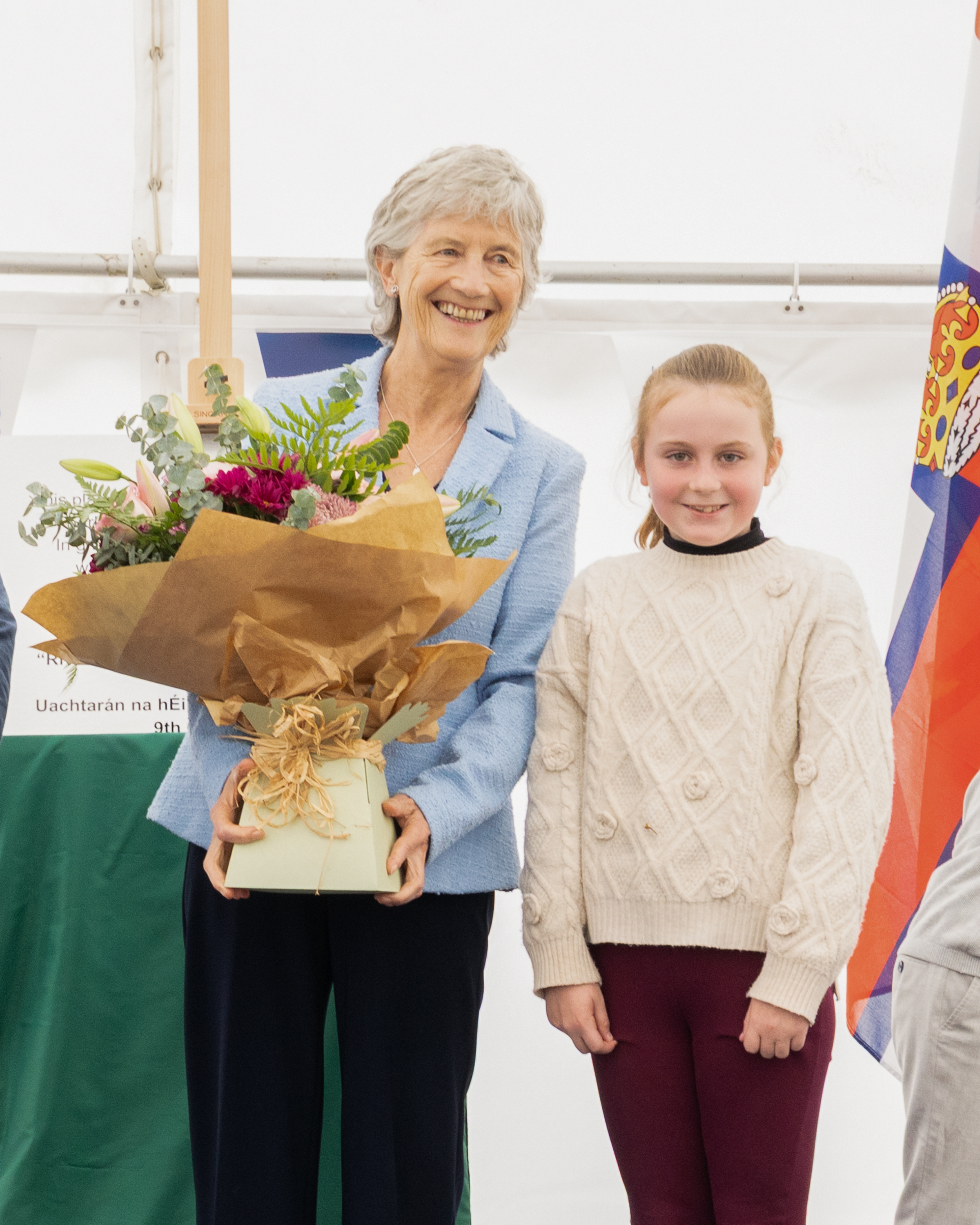 President Catherine Connolly is presented with flowers by Nell McElheron