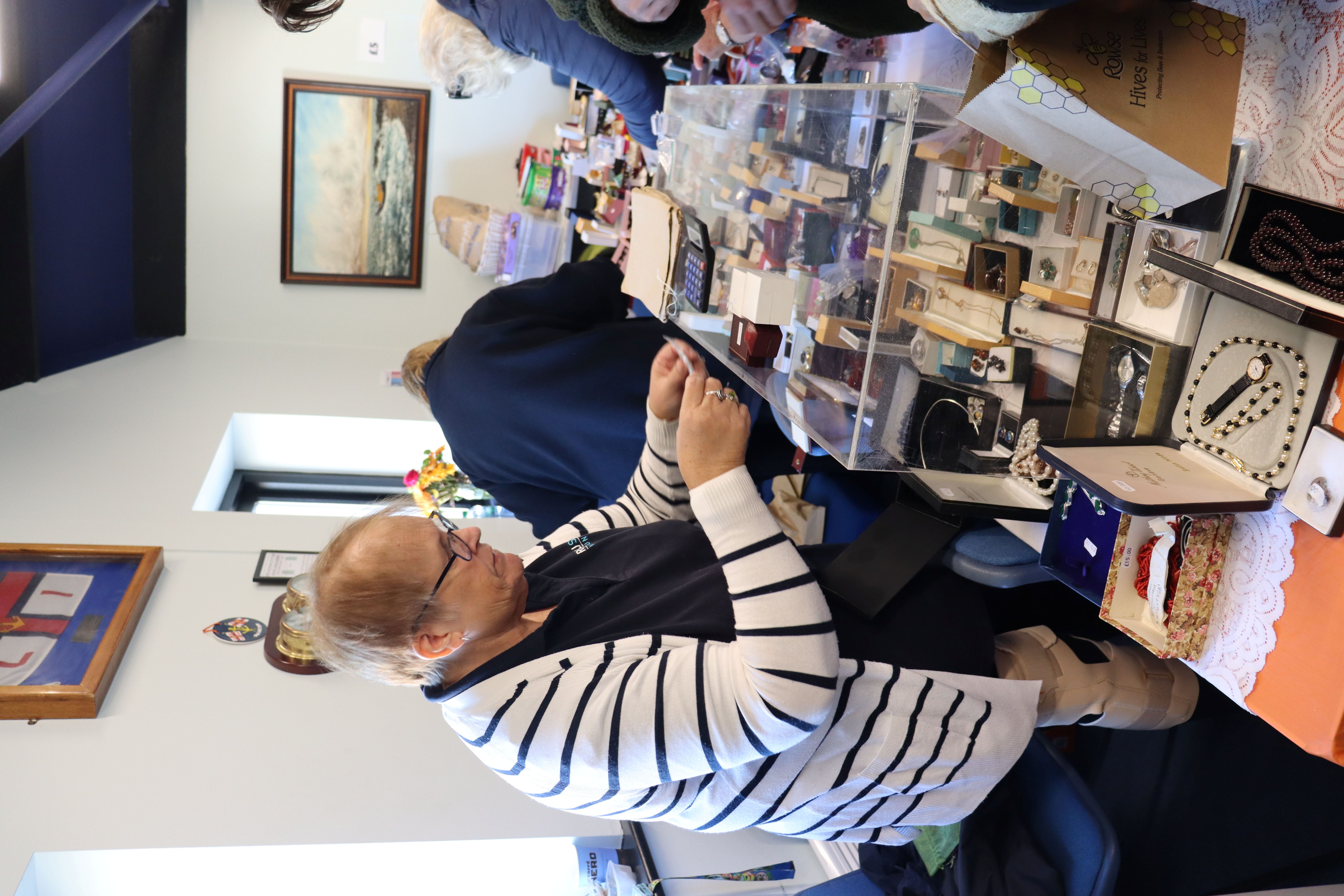 An RNLI volunteer serving a customer
