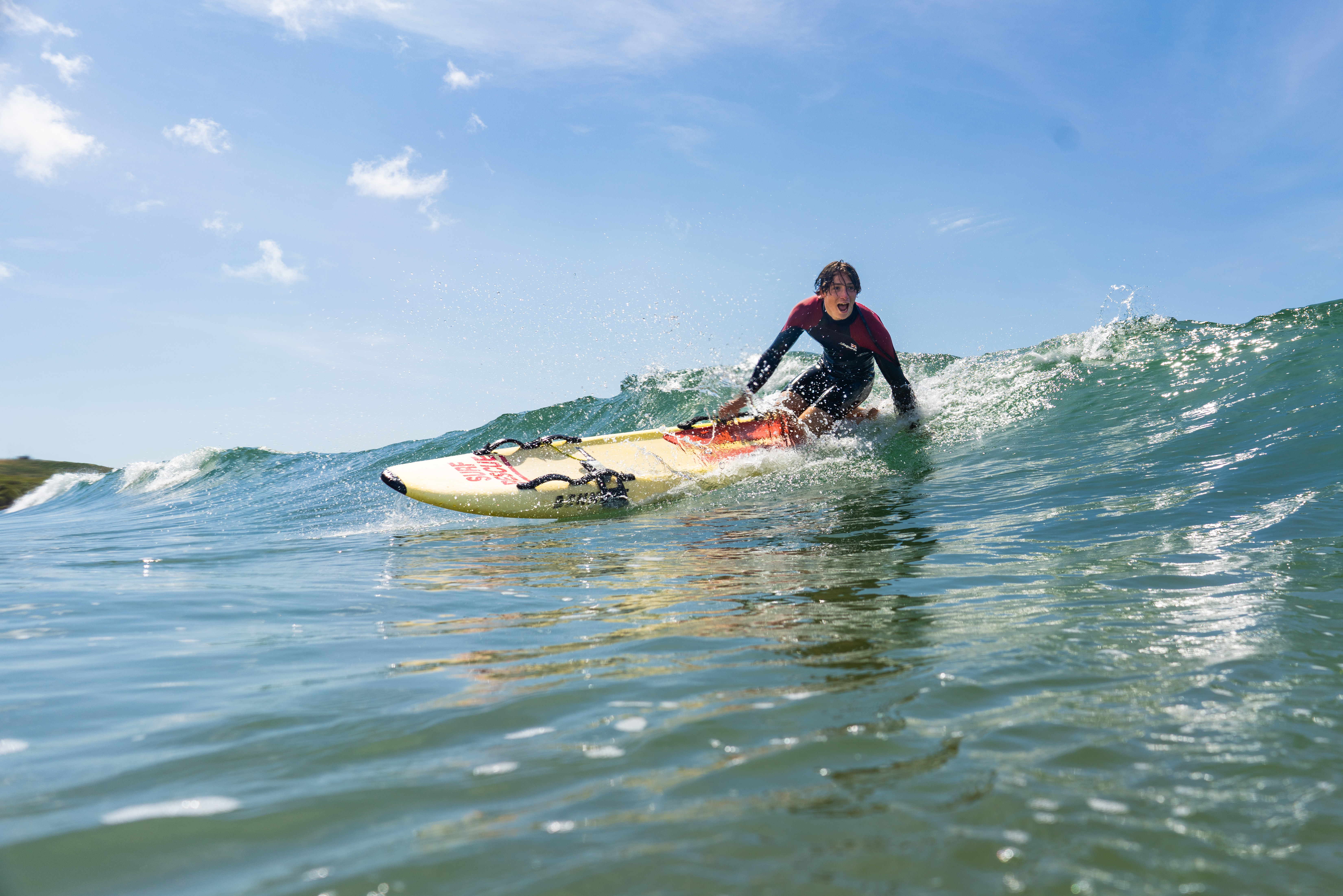 Lifeguard patrolling the sea at Freshwater West beach, Pembrokeshire using a rescue board.