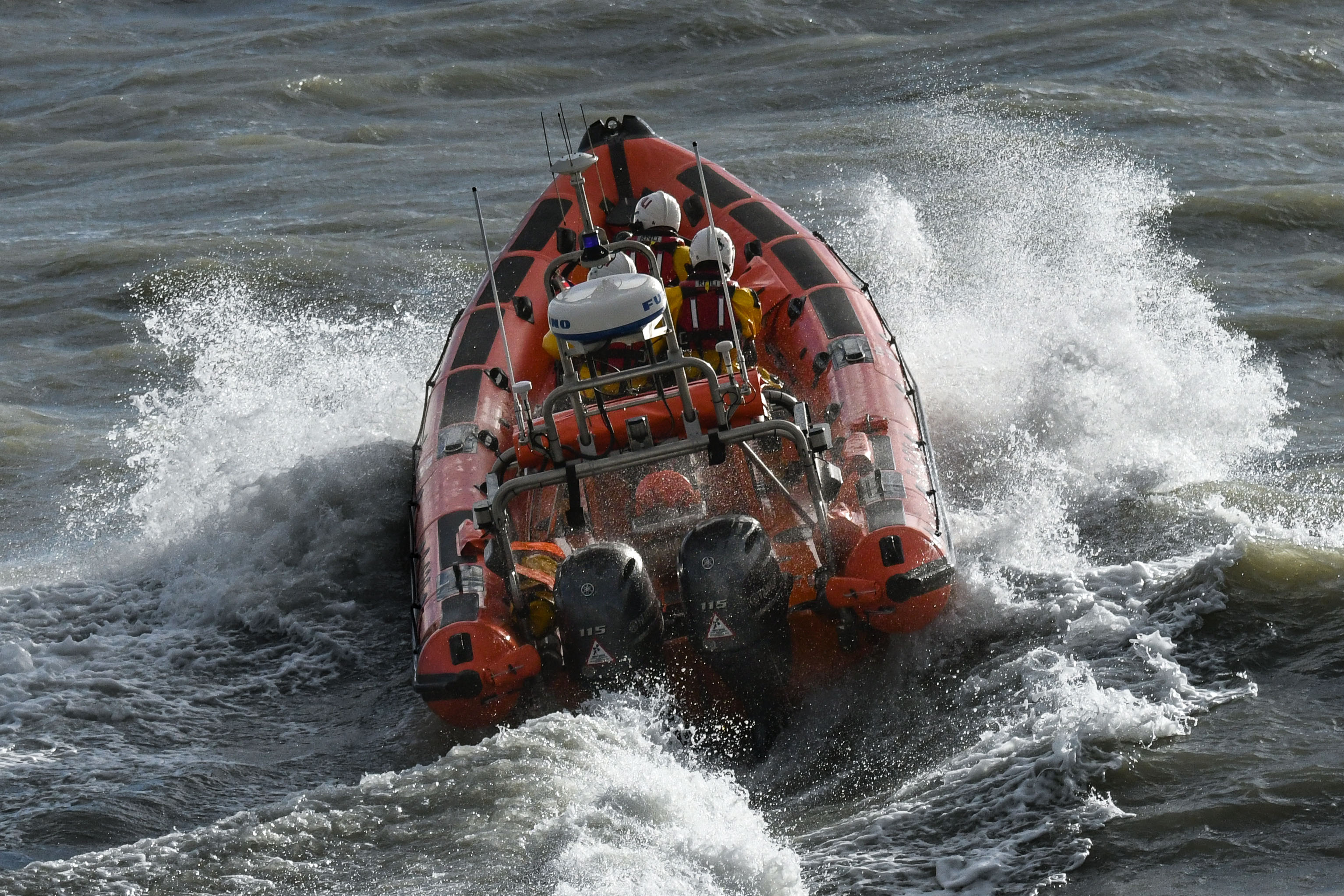 picture of an B Class Inshore Lifeboat in rough conditions, the orange boat standing out against the rough dark seas