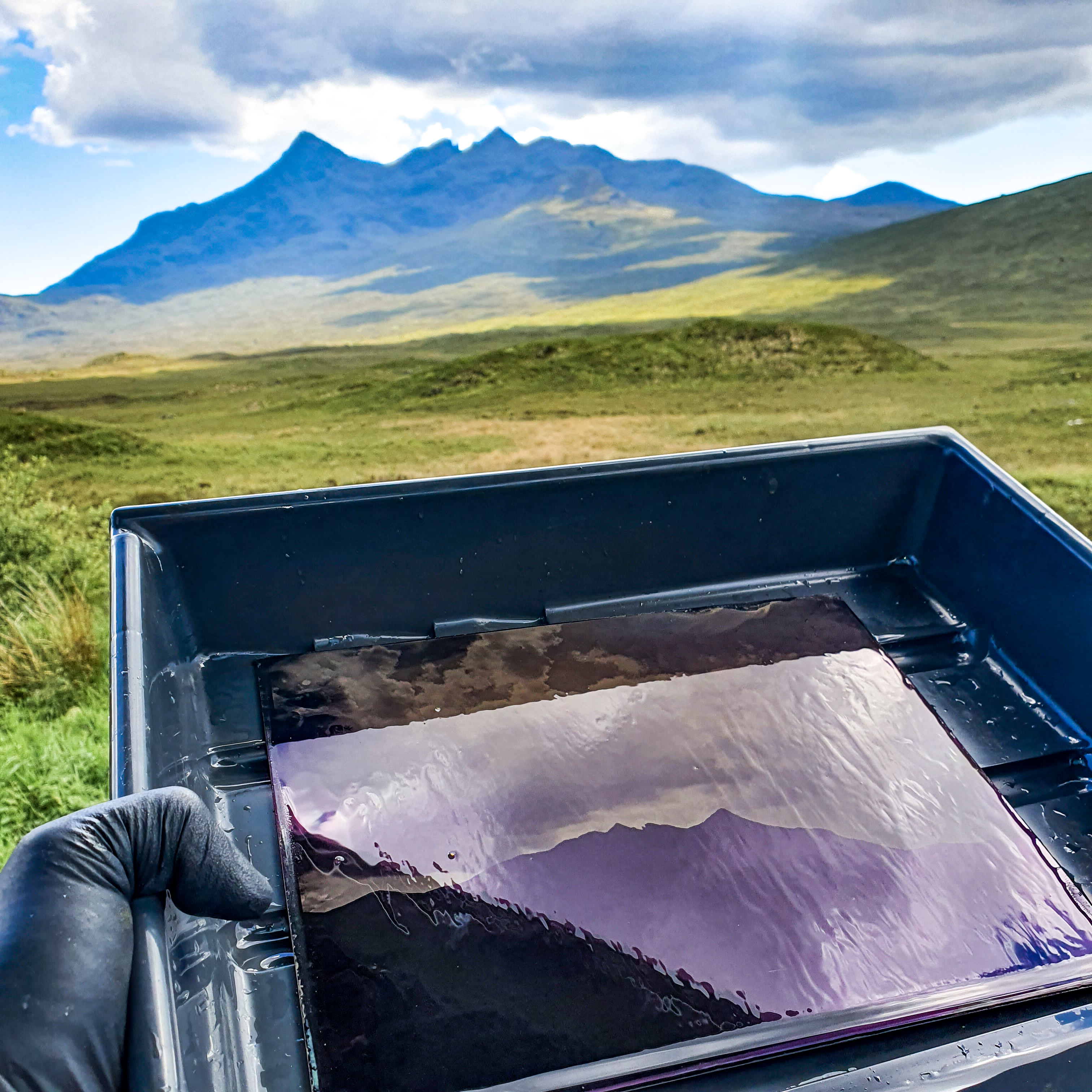 The photography plate under development on location with the Cuillin mountains in the background.