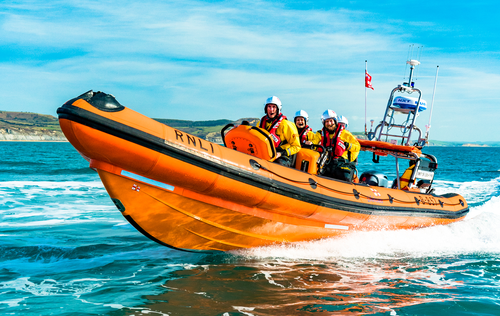 Orange lifeboat travelling at speed