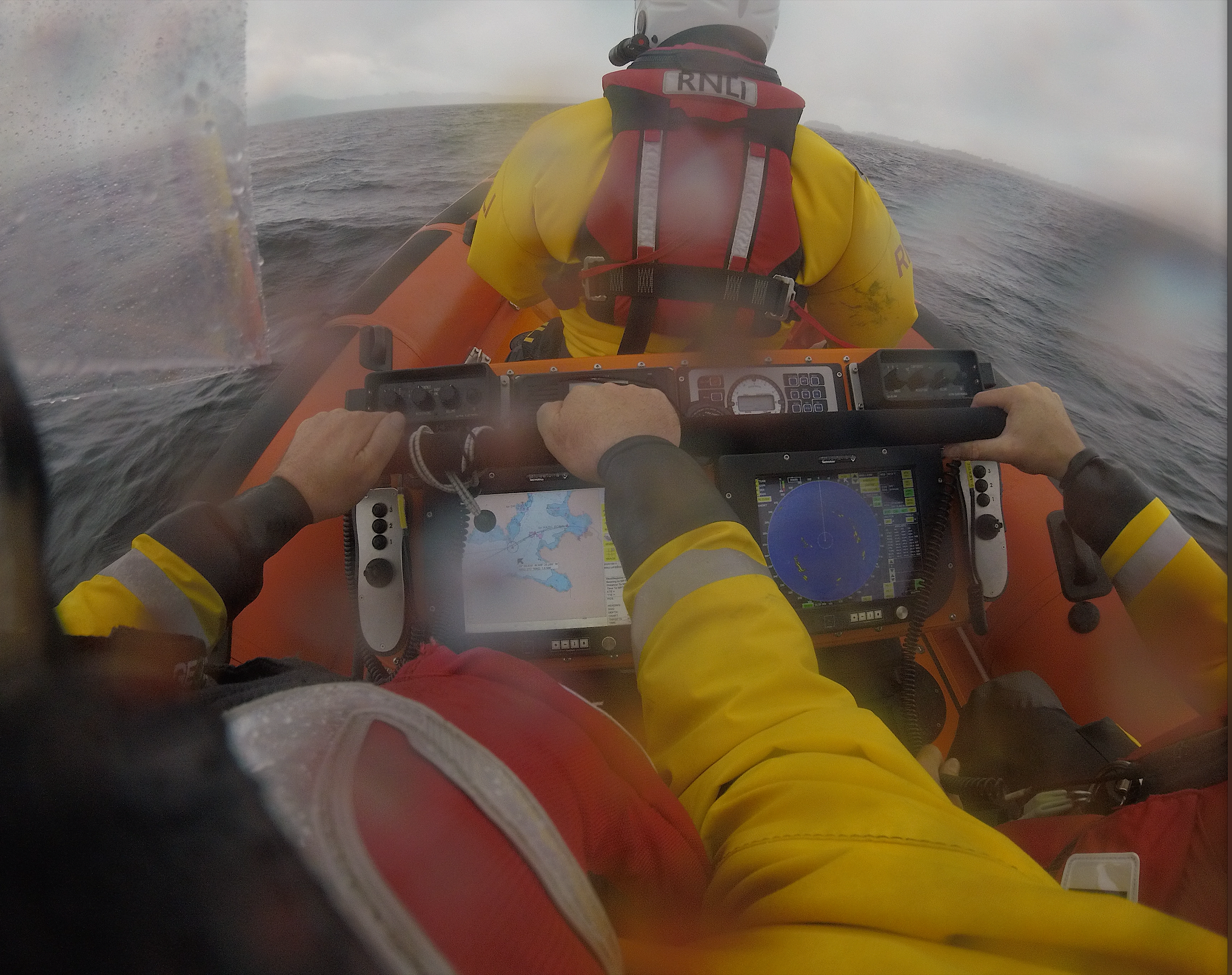 View from seat 2 of the lifeboat, with naviagator and RADAR screens on view and the rough conditions of the lake over the helms shoulders