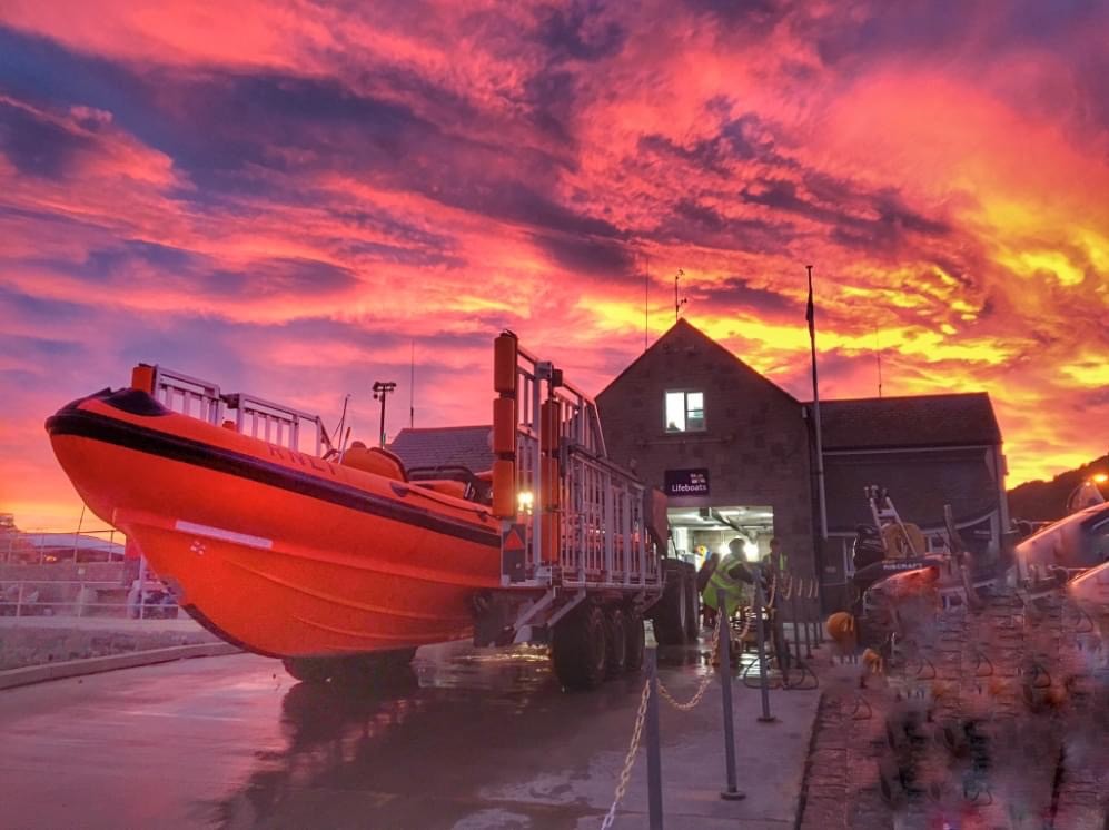 lifeboat outside lifeboat station against the setting sun