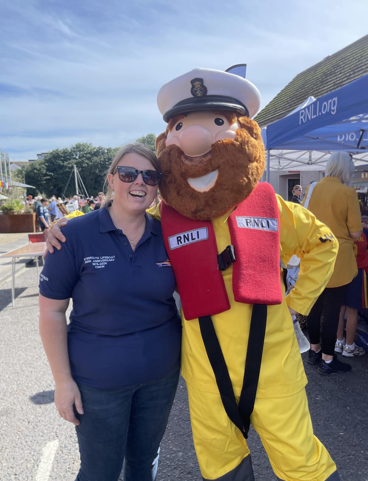 Woman with man in lifeboat mascot suit.