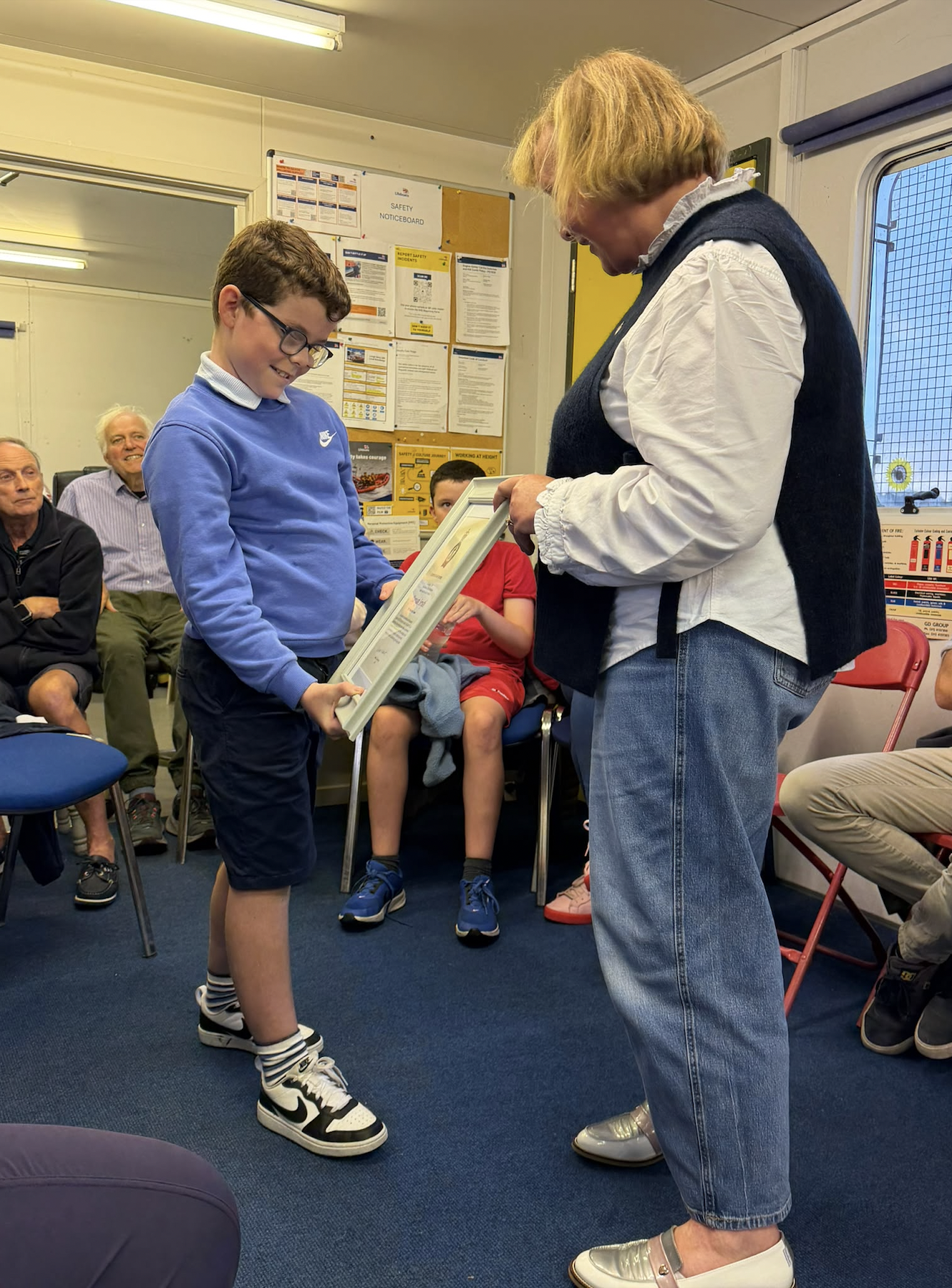 A look of joy and delight on Darragh's face as he recieves his Certificate of Thanks from RNLI volunteer Eleanor Hooker
