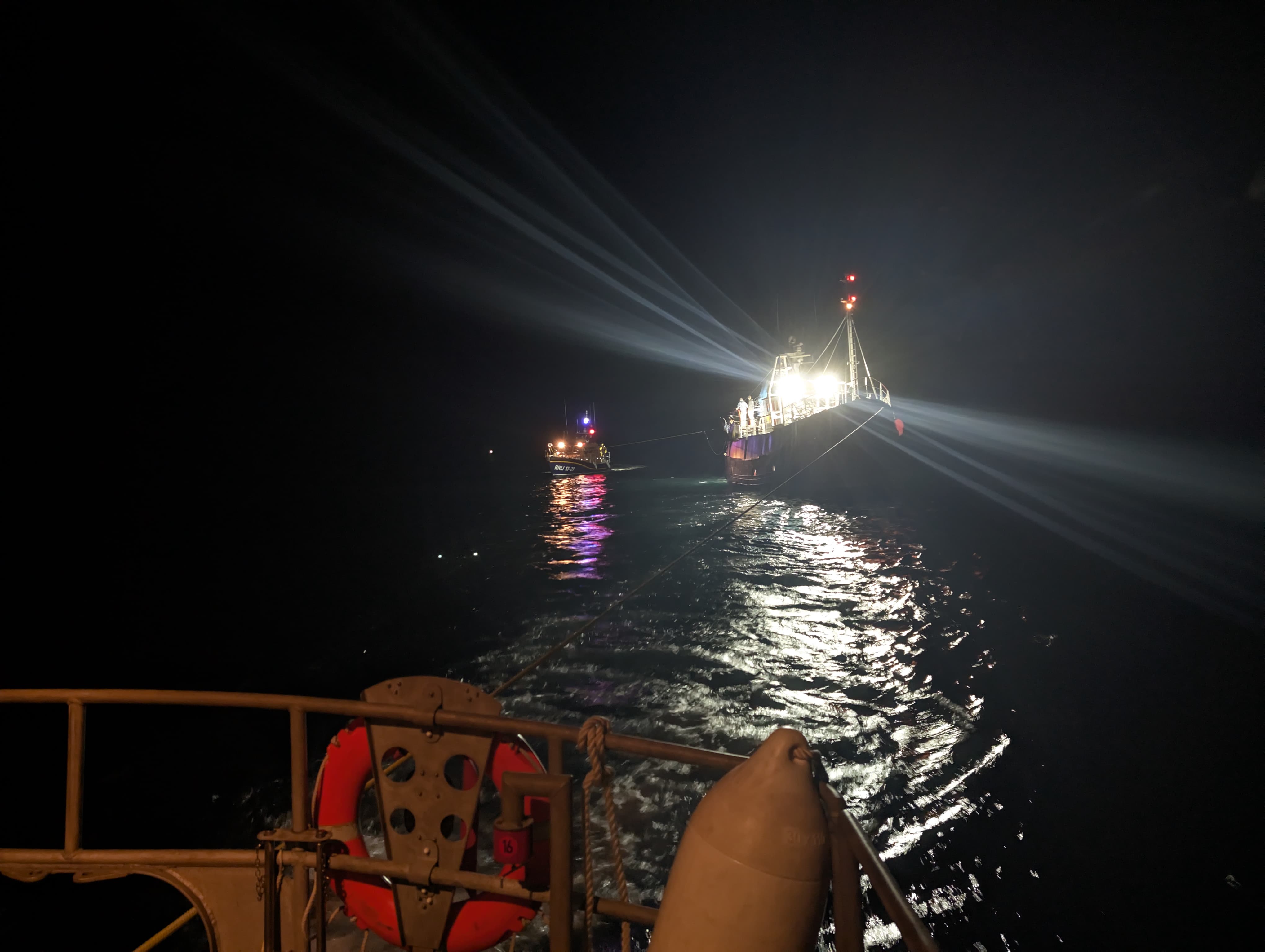 Fishing boat being towed with another lifeboat behind