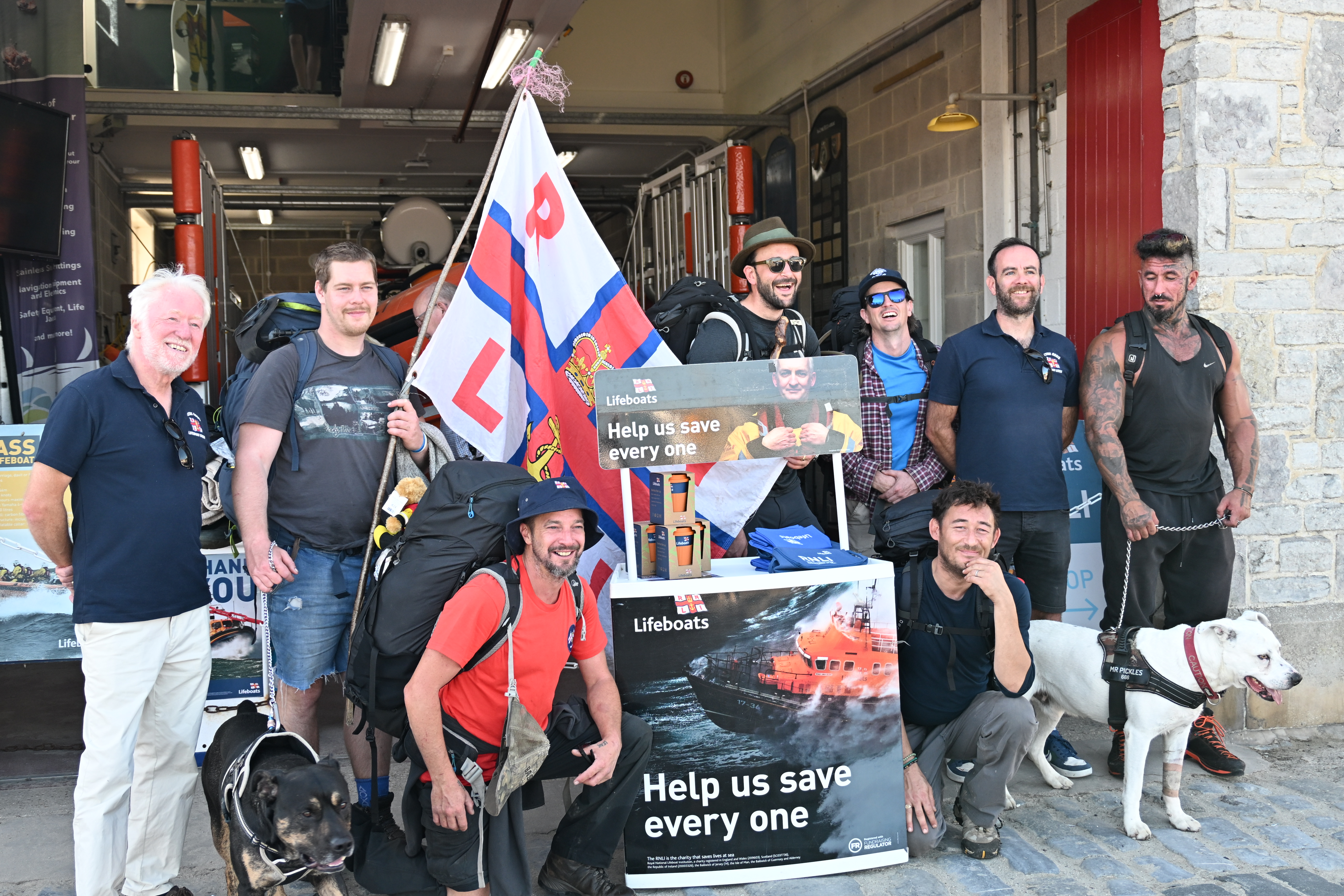 Group of men outside lifeboat station with RNLI volunteers
