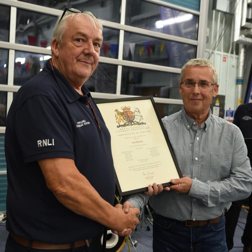Gerallt Williams, Chair of Pwllheli RNLI presenting certificate of service to Neil Roberts