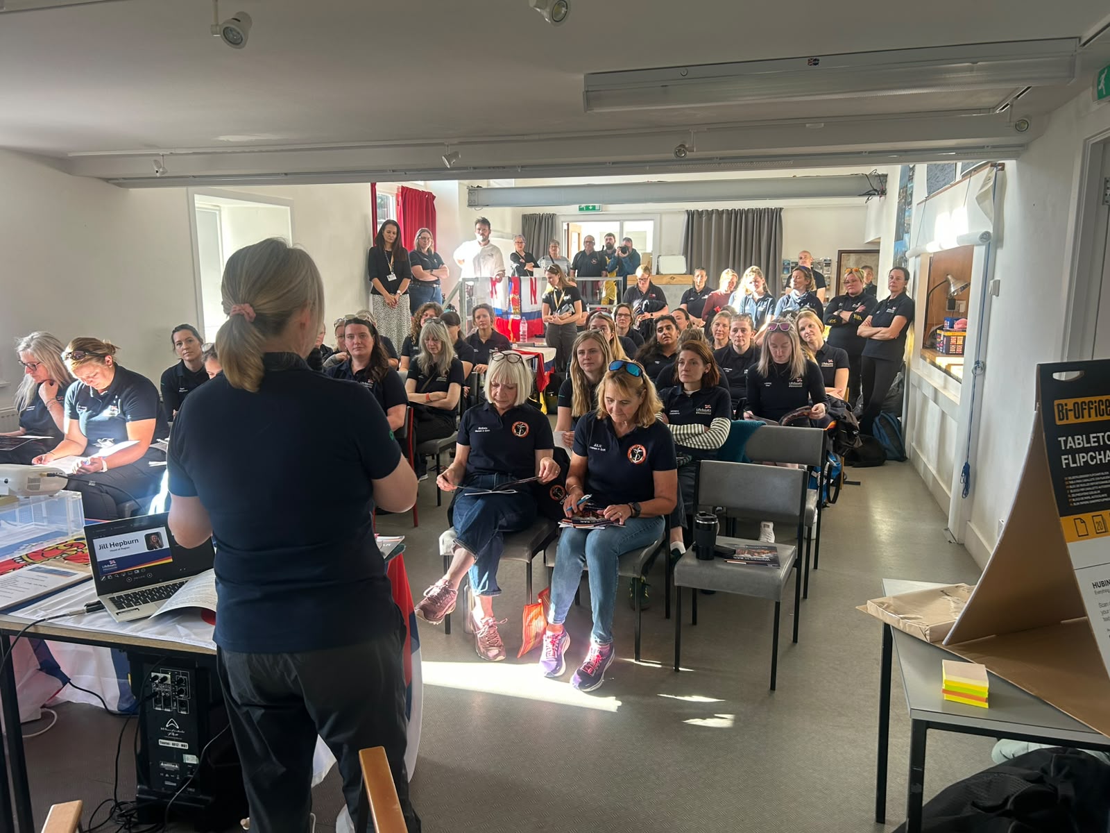 Woman delivers talk to room of women.