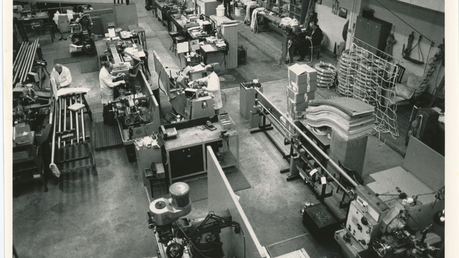 Black and white image of workshop interior and engineers at work