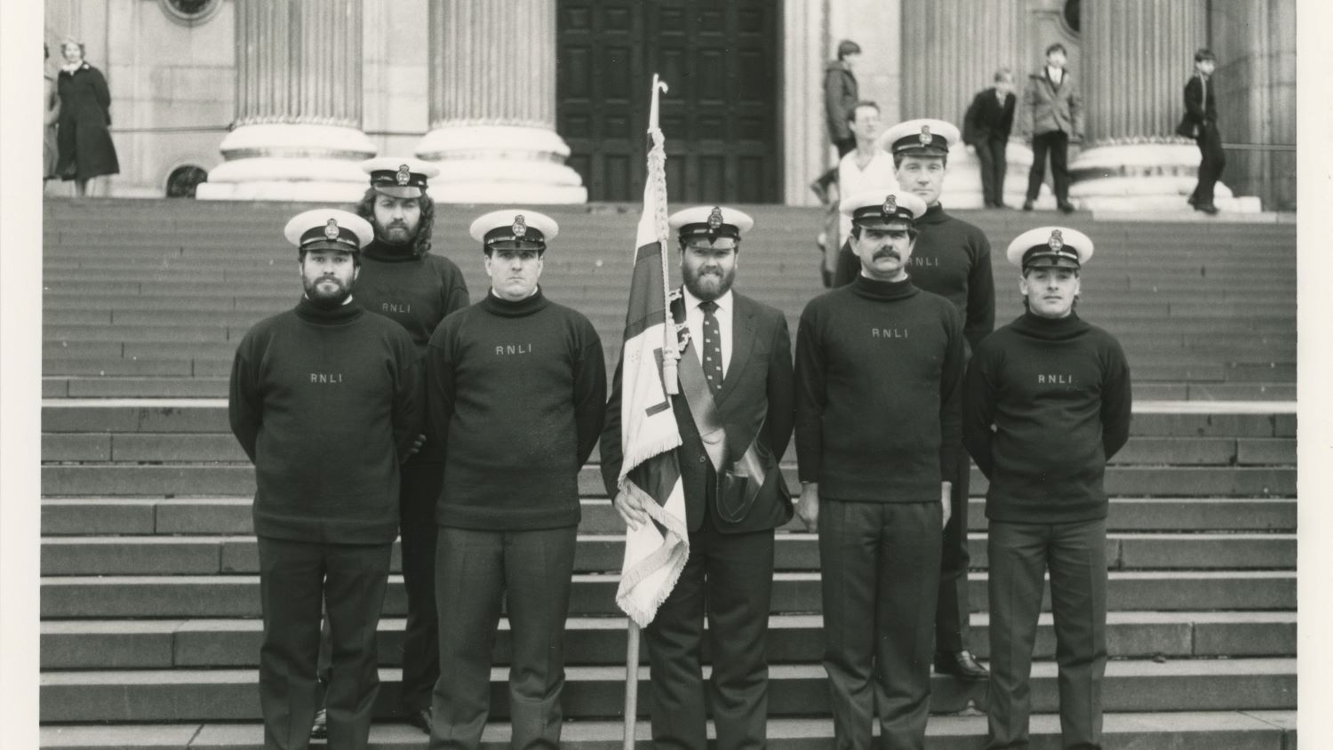 Black and white image of crew including flagbearer outside St Paul's Cathedral