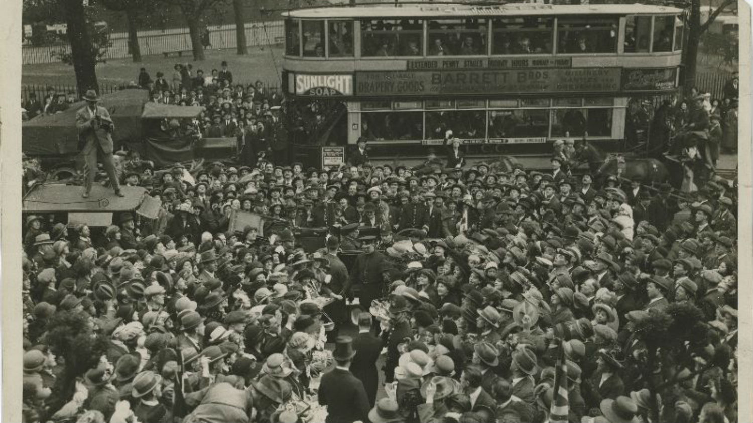 Black and white image of large crowd surrounding car of Prince of Wales