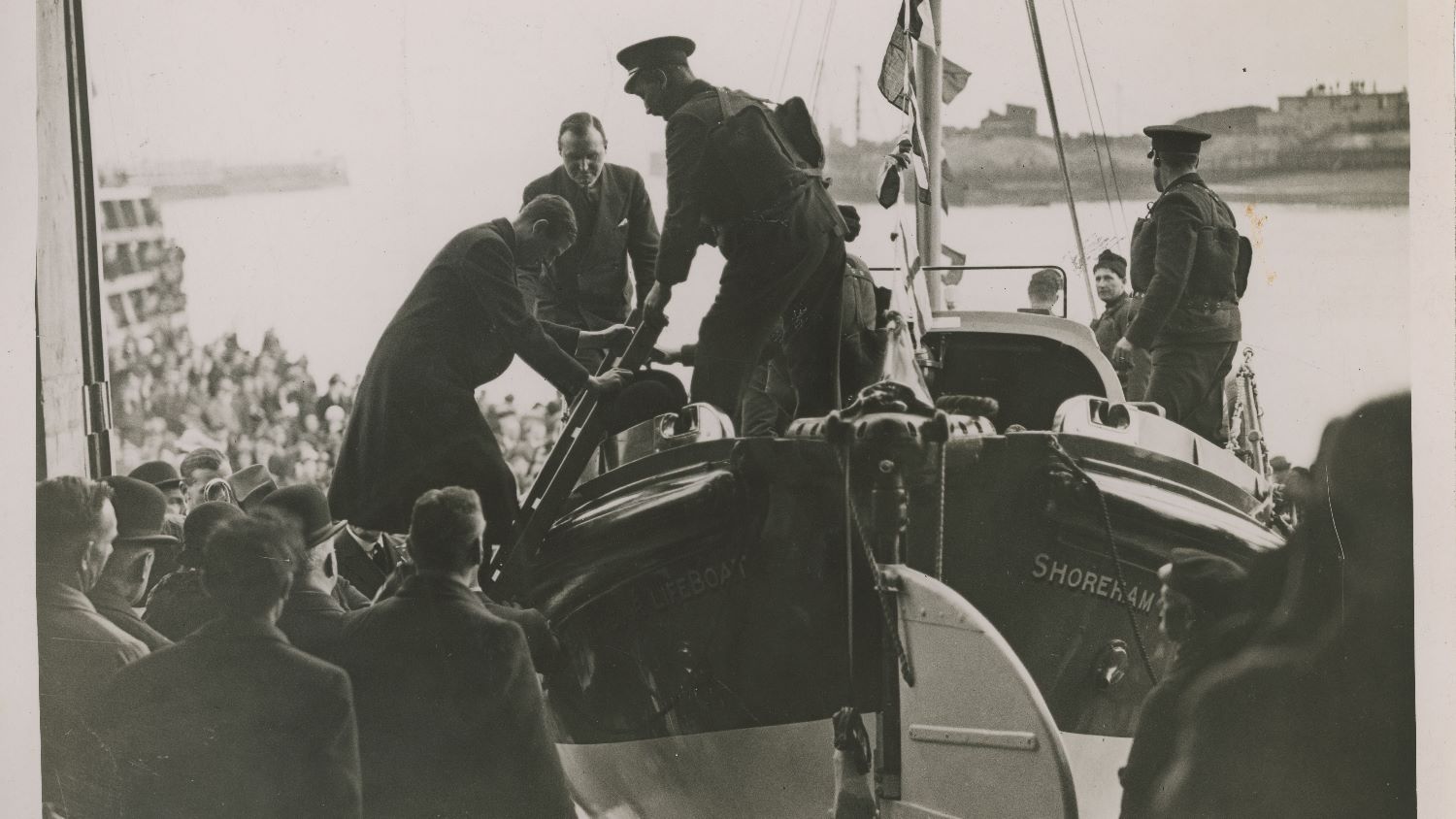 Black and white image of Prince George climbing into lifeboat at opening of Shoreham lifeboat station