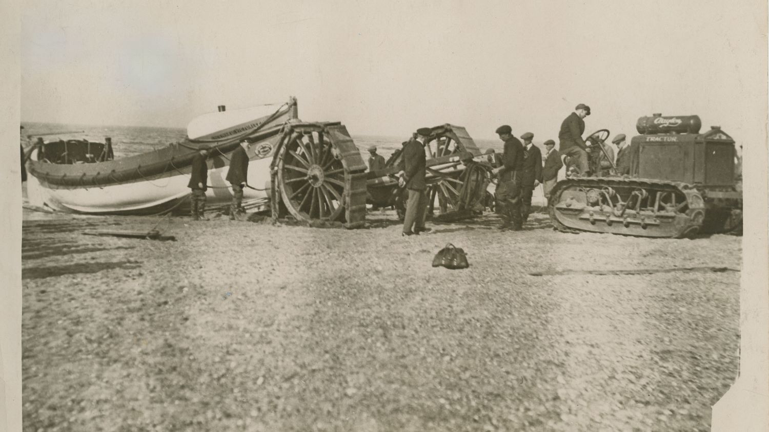 Black and white image of lifeboat and tractor on beach