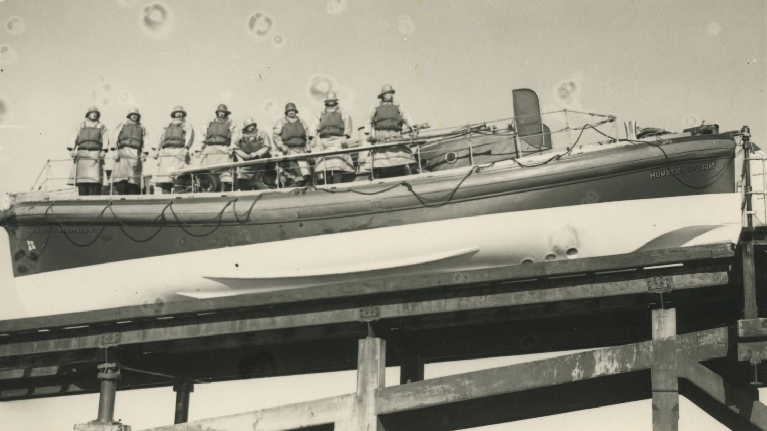 Black and white image of crew inside Humber lifeboat on slipway