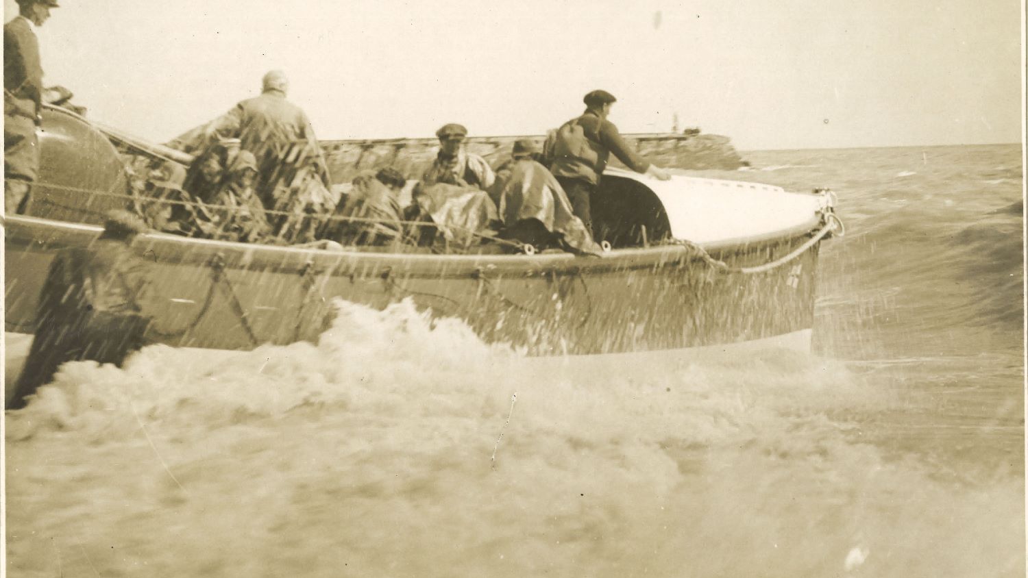 Black and white image of lifeboat launch from beach