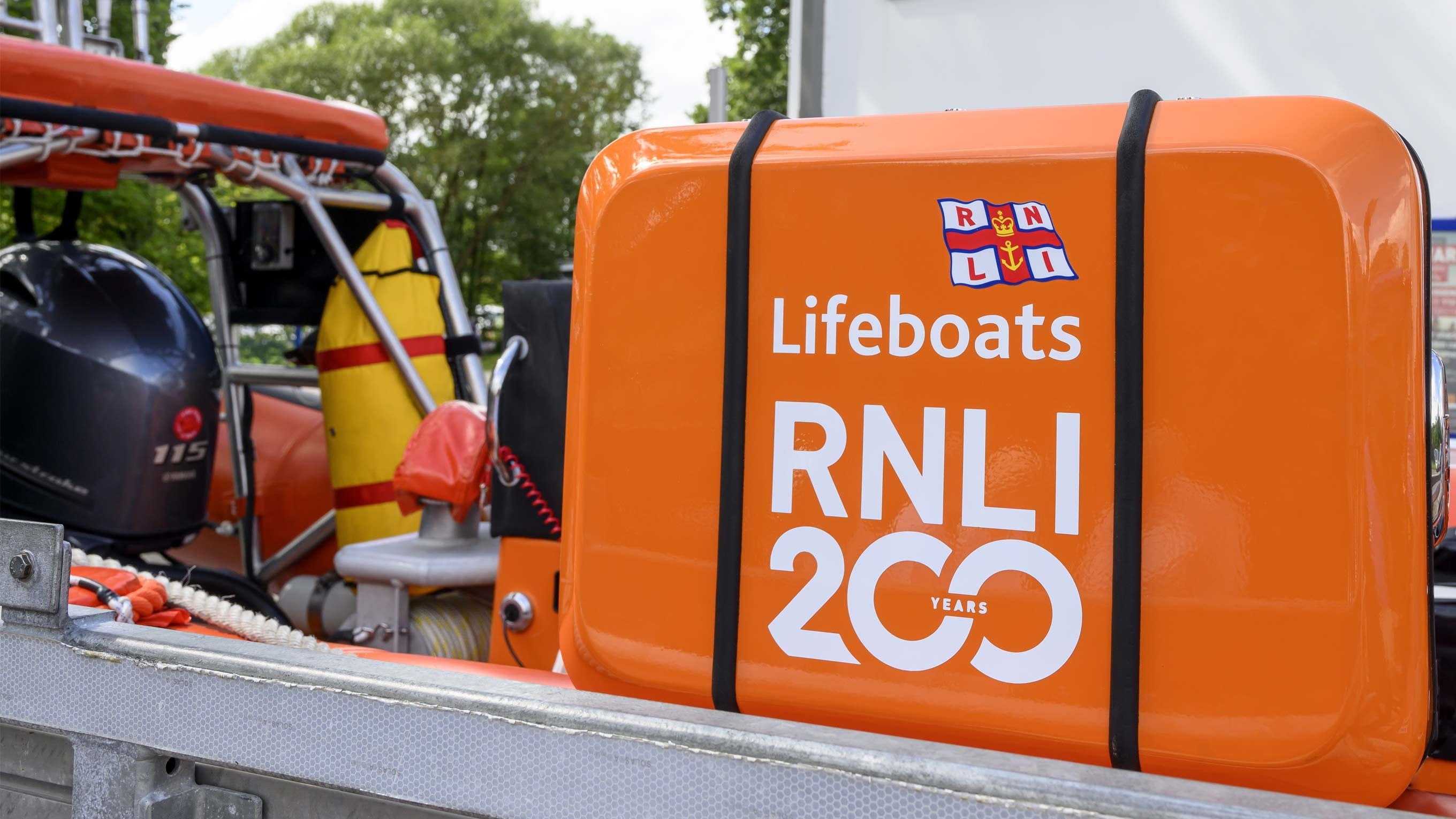 A bright orange carry case with Lifeboats RNLI 200 written across it sits on a lifeboat on the back of the launch carriage