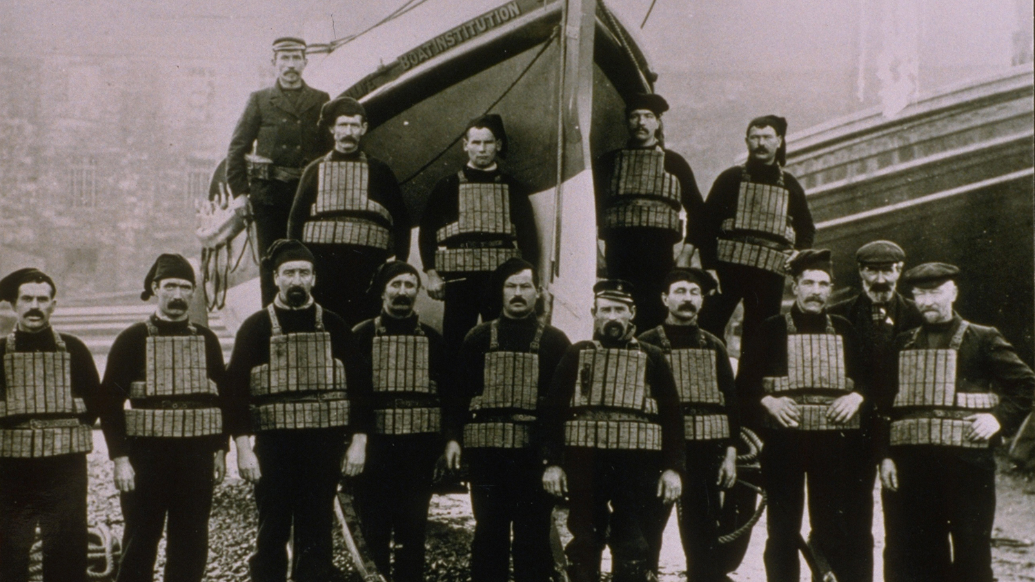 Abersoch lifeboat crew wearing cork lifejackets and standing in front of their Watson class lifeboat