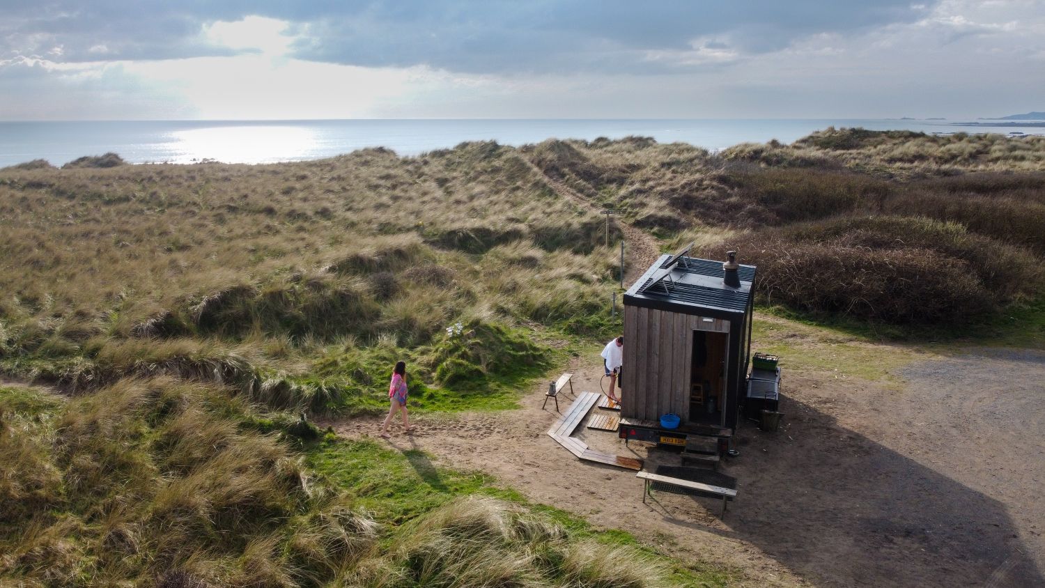 An outdoor sauna on the sand dunes, looking out towards the sea