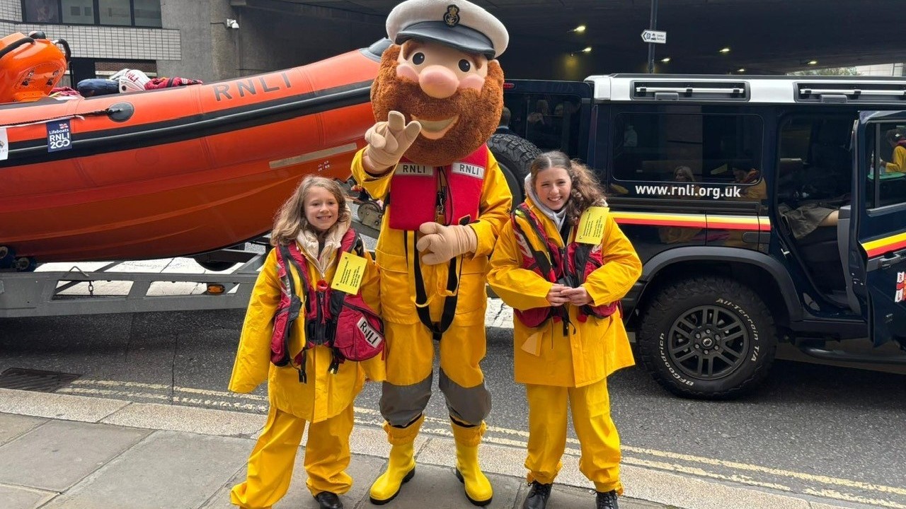 Stormy Sam and some young volunteers wearing decommissioned kit