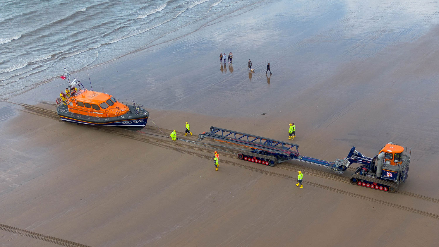 Scarborough RNLI volunteers are recovering their Shannon class lifeboat on the beach using the Shannon Launch and Recovery System. The photo has been taken from a bird’s-eye view.