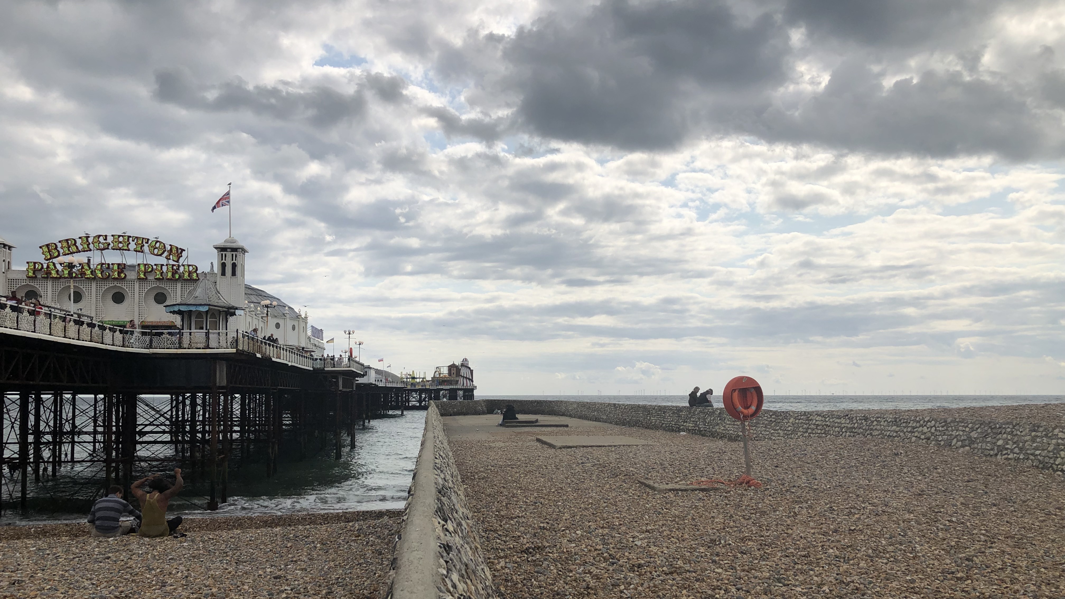 A landscape image of Palace Pier West Beach - the beach is pebbled. To the left, Brighton Pier is visible