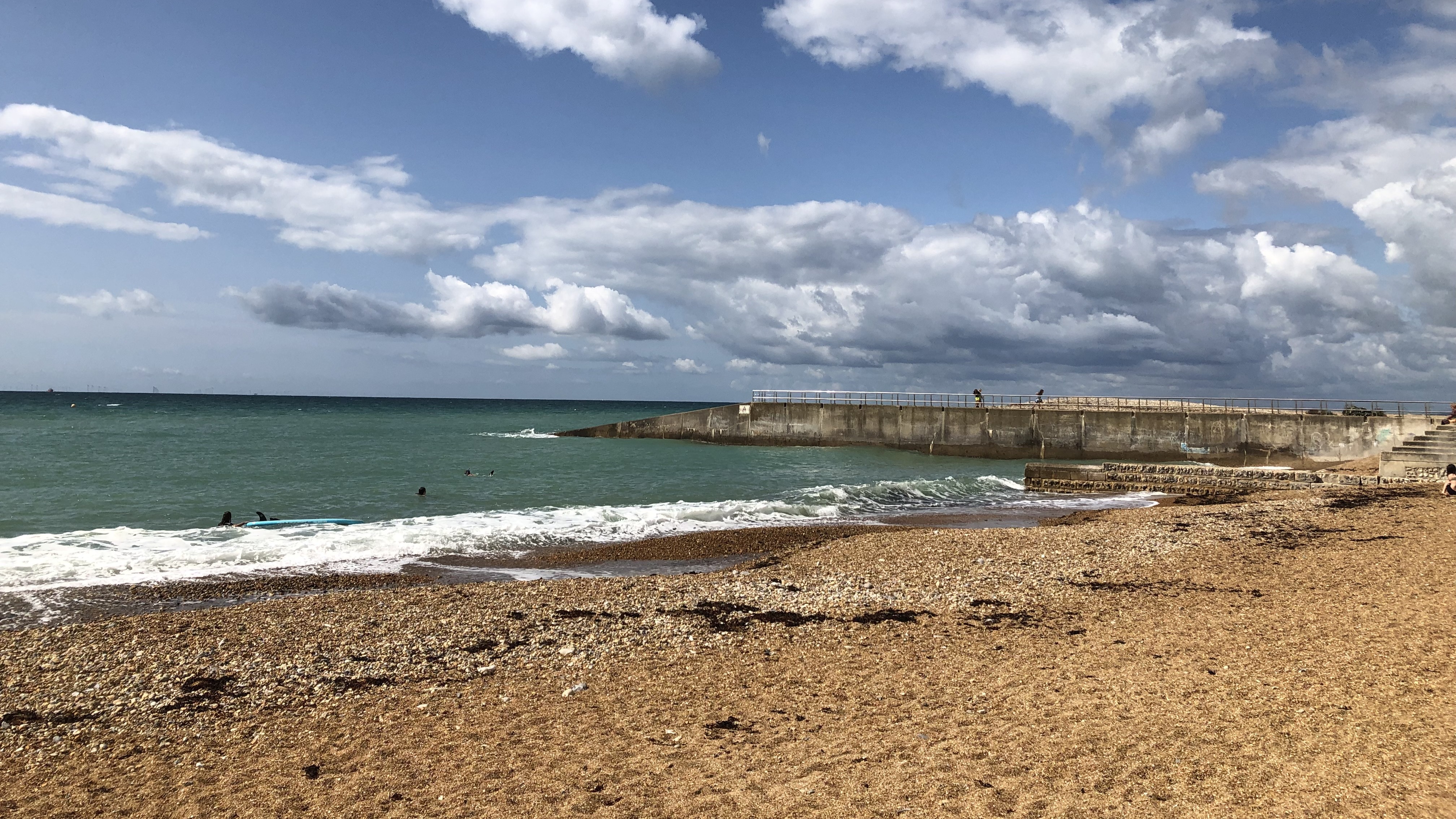A horizontal landscape image of Saltdean beach on a sunny day. No people are present. 