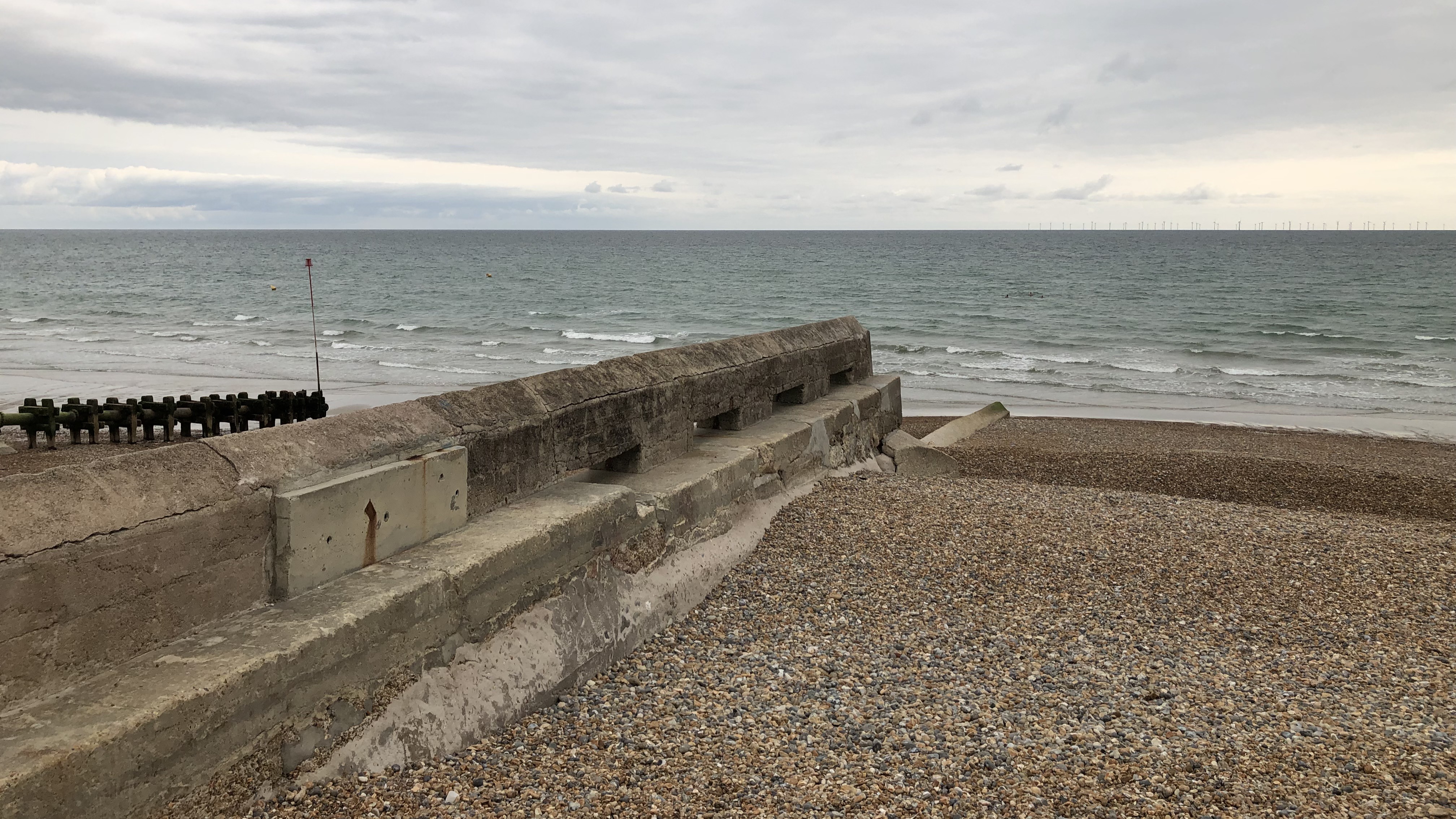 West Hove Beach on an overcast day. The shoreline is pebbled; there are no people visible on the beach. 