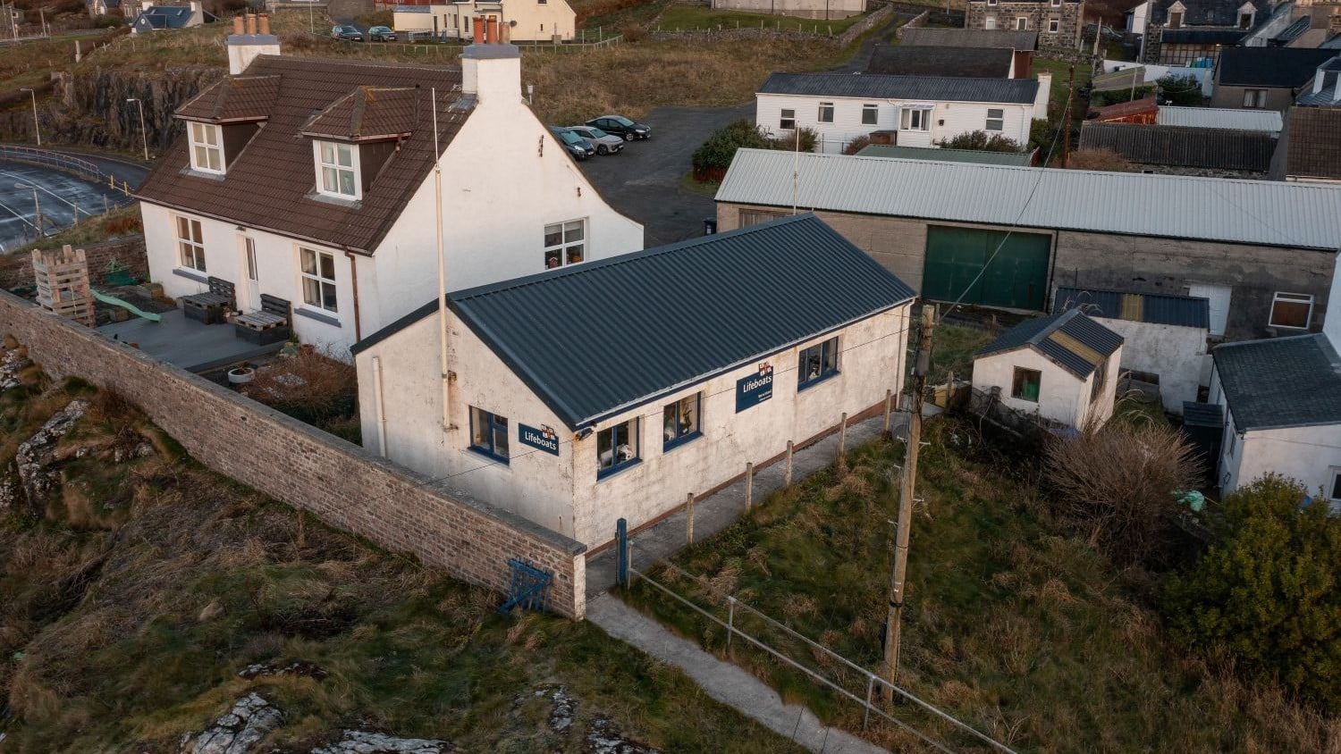 One storey white building with pointy grey roof.