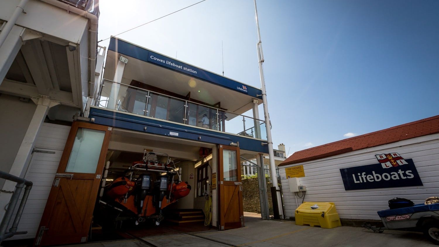 A two storey building with a balcony above boatshed doors.