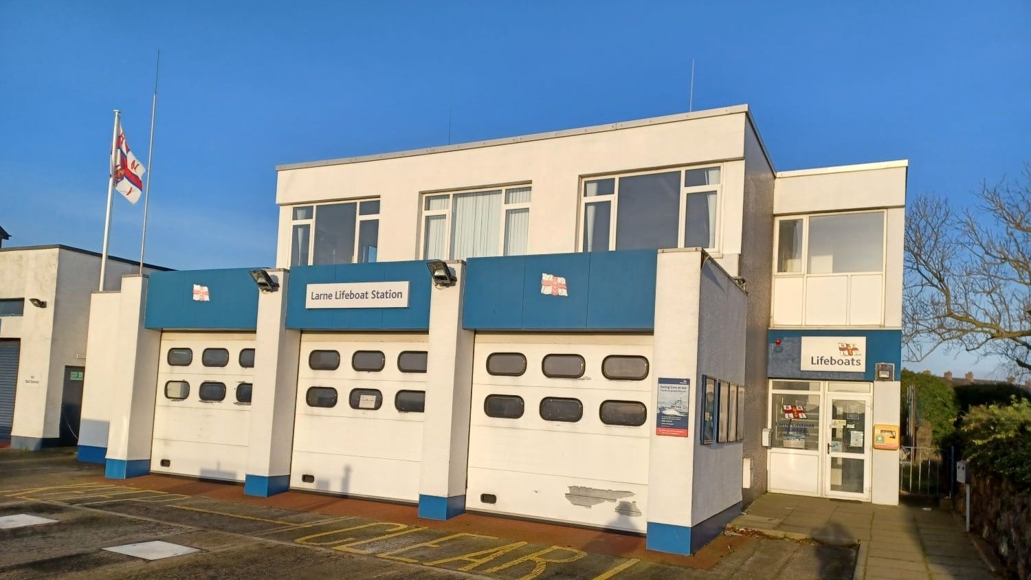 A two-storey cream and blue building with flat roof.