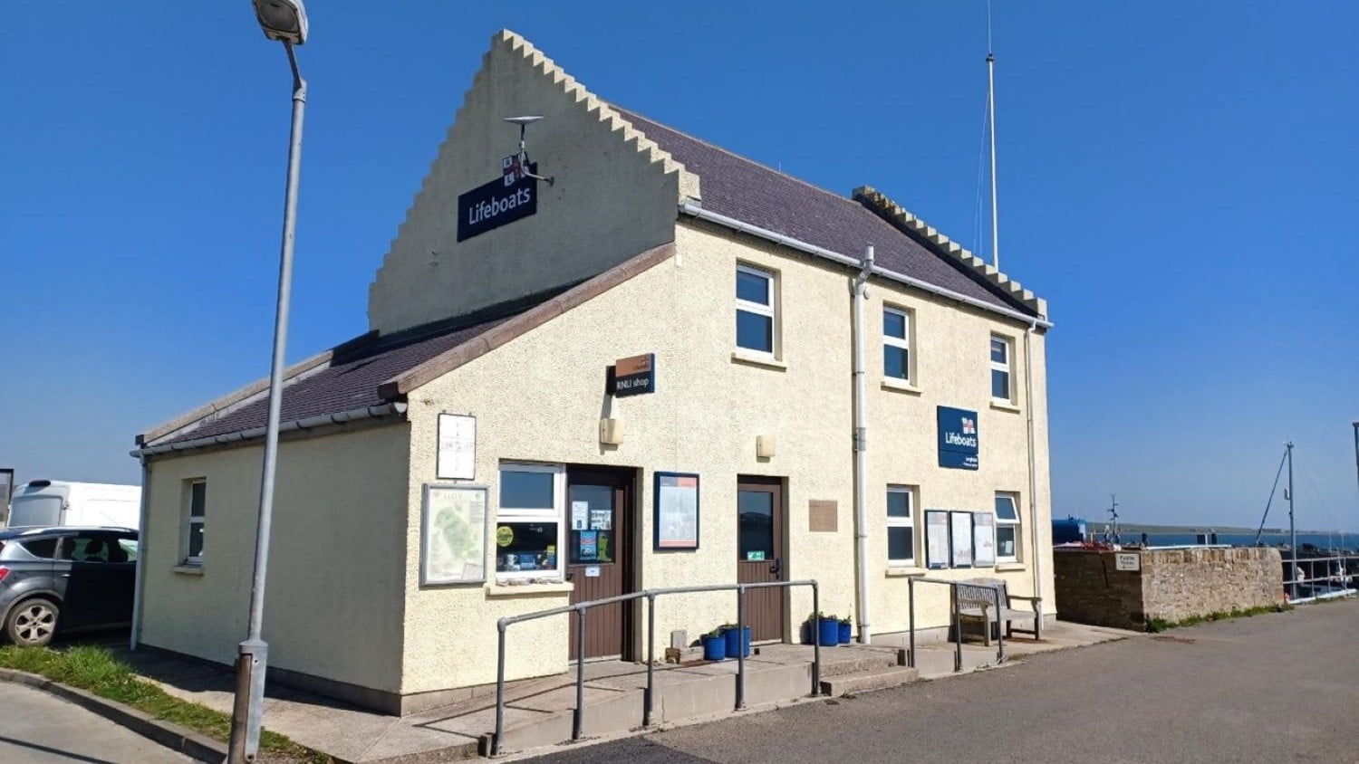 A white two storey building against a blue sky.