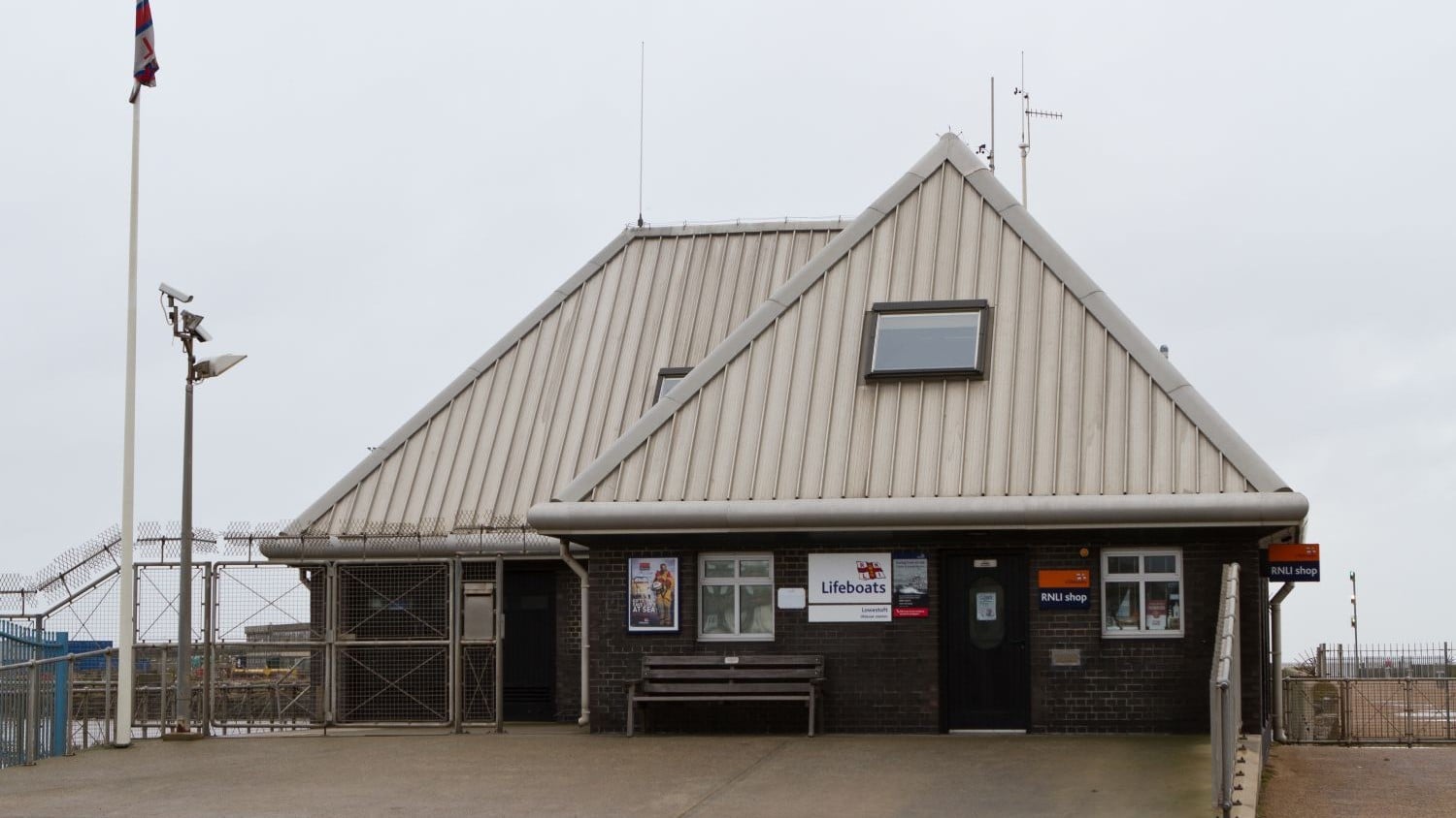 A brown brick building with grey pointy roof.