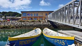 A two-storey wooden building on a rocky water edge.