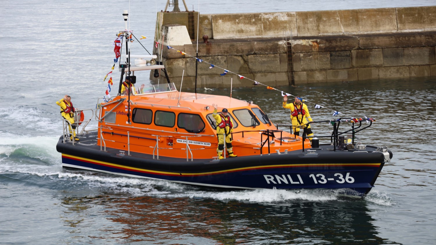 RNLI Seahouses lifeboat crew waving from their Shannon class lifeboat