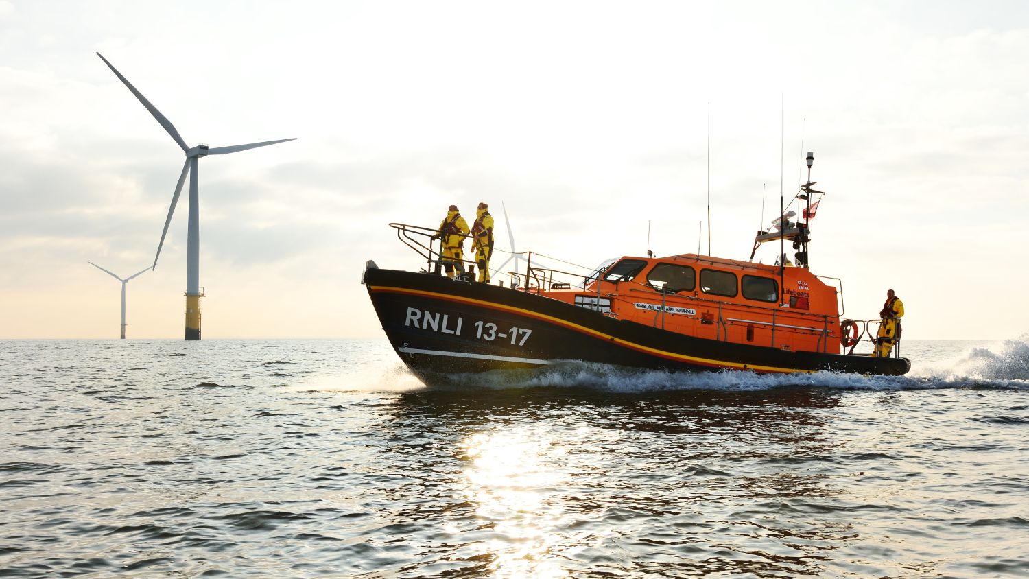 Skegness Shannon class lifeboat 13-17 Joel and April Grunnill at sea during a search and rescue exercise, wind farm in the background.