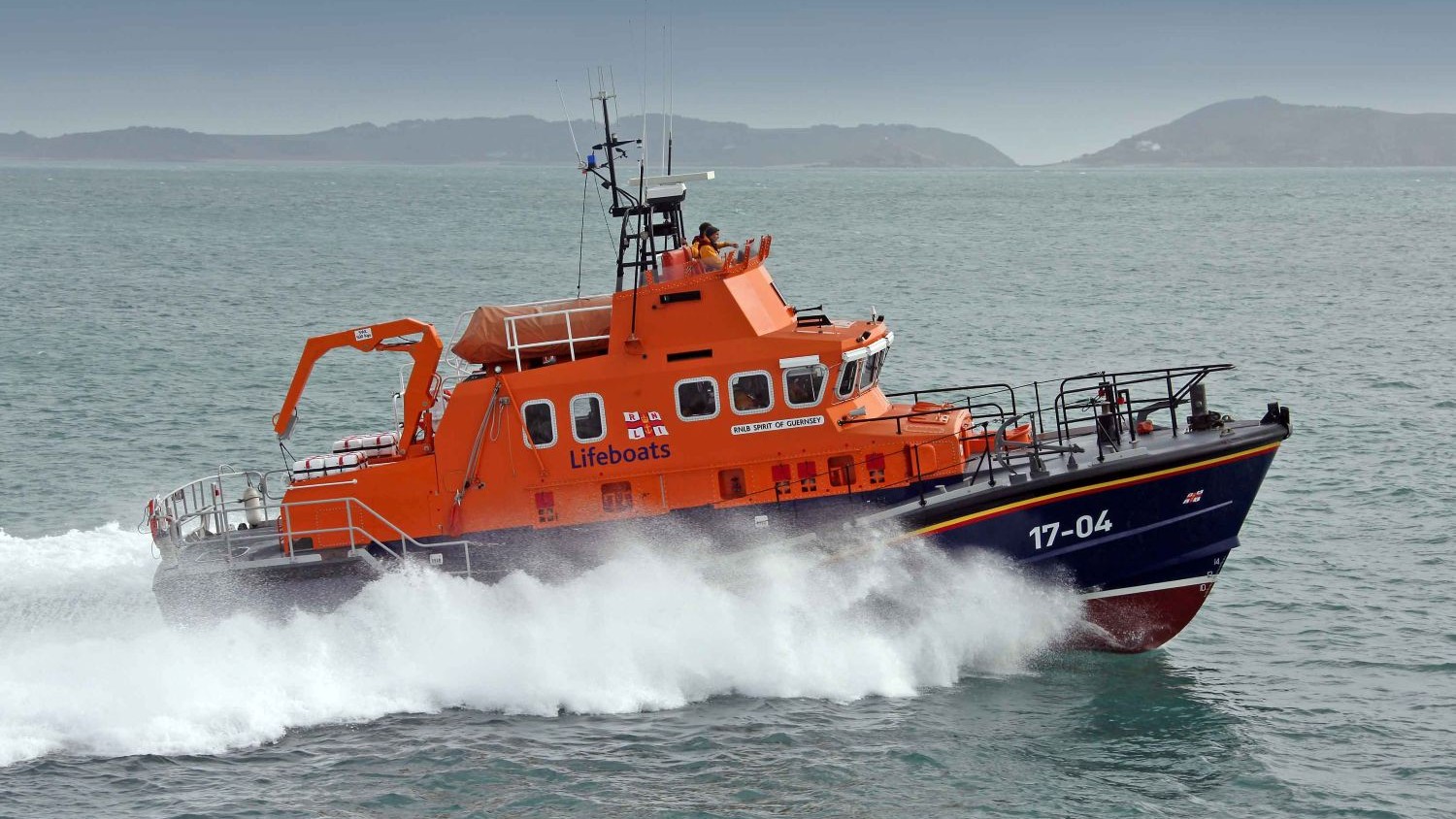 An ALB creates spray with an island in the background.