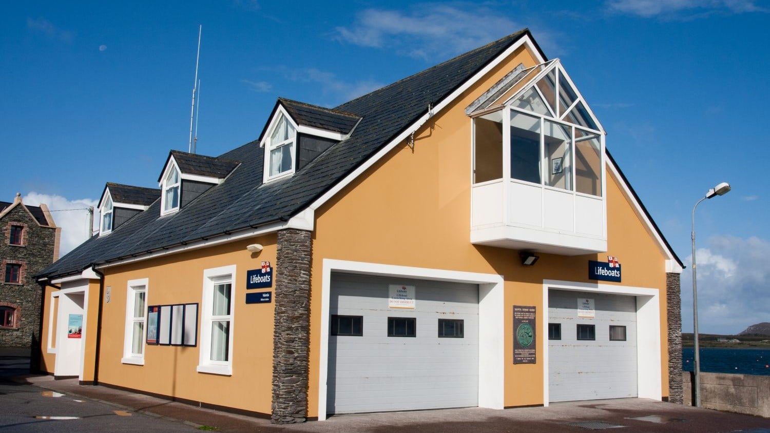 A two storey yellow building with a pointy roof.