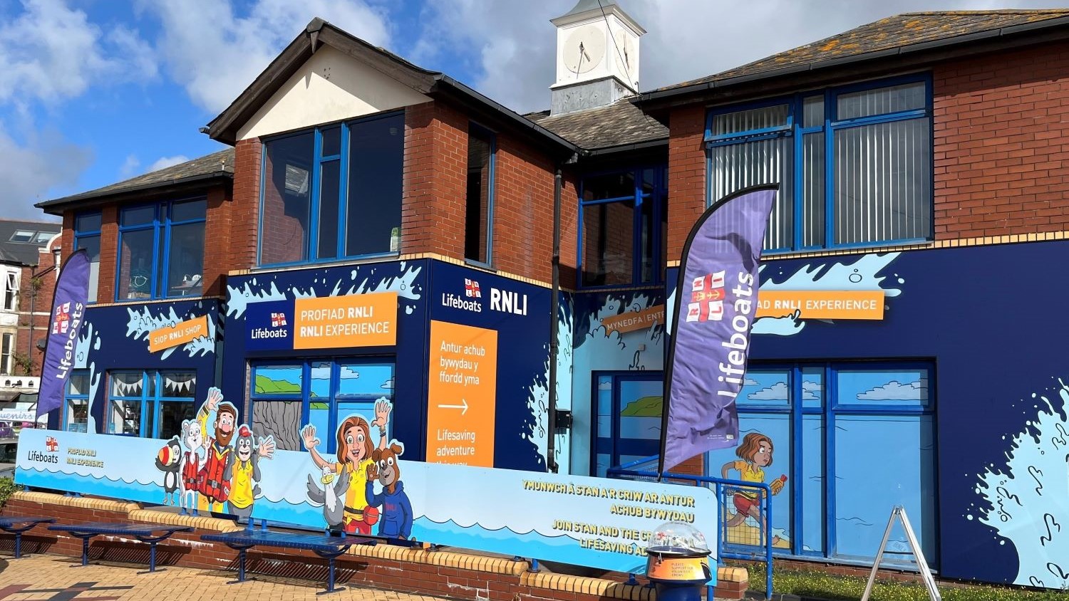 A blue and white building with a lifeboat sign on it.