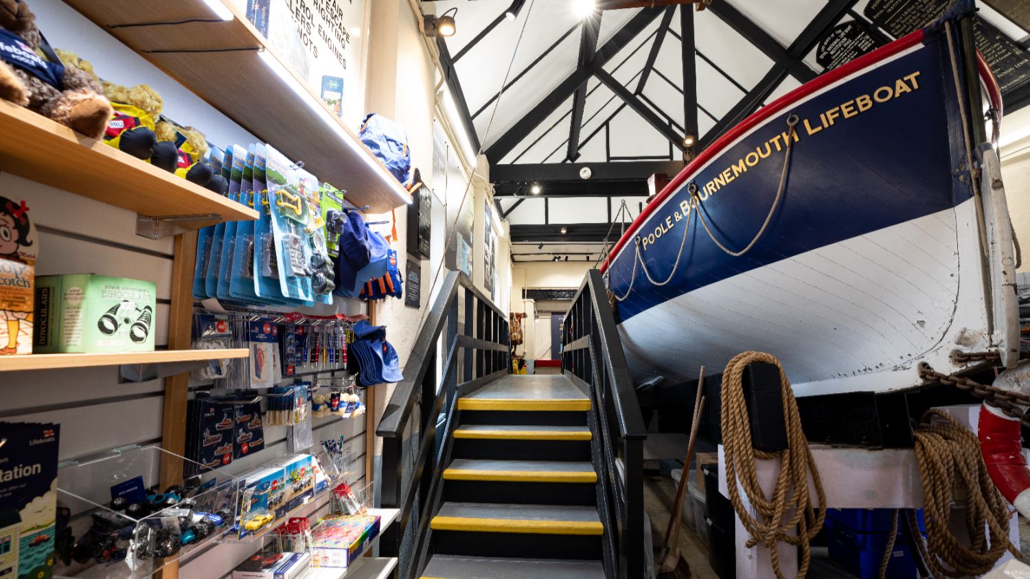 The interior of the Poole Old Lifeboat Museum Shop showing part of the shop display and the lifeboat, Thomas Kirk Wright
