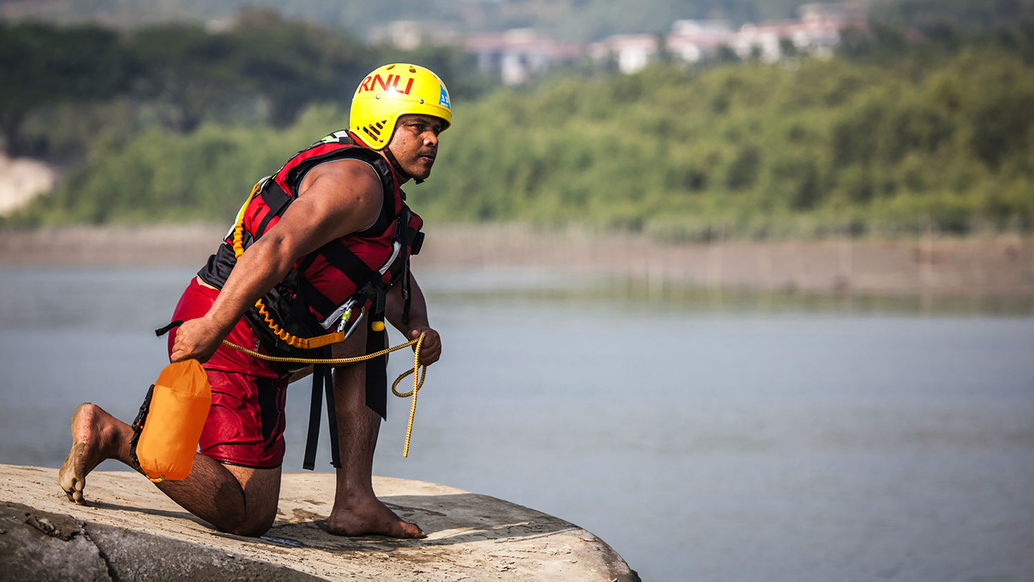 Flood Rescue trainer in Bangladesh ready to deploy a rescue throwline by river.